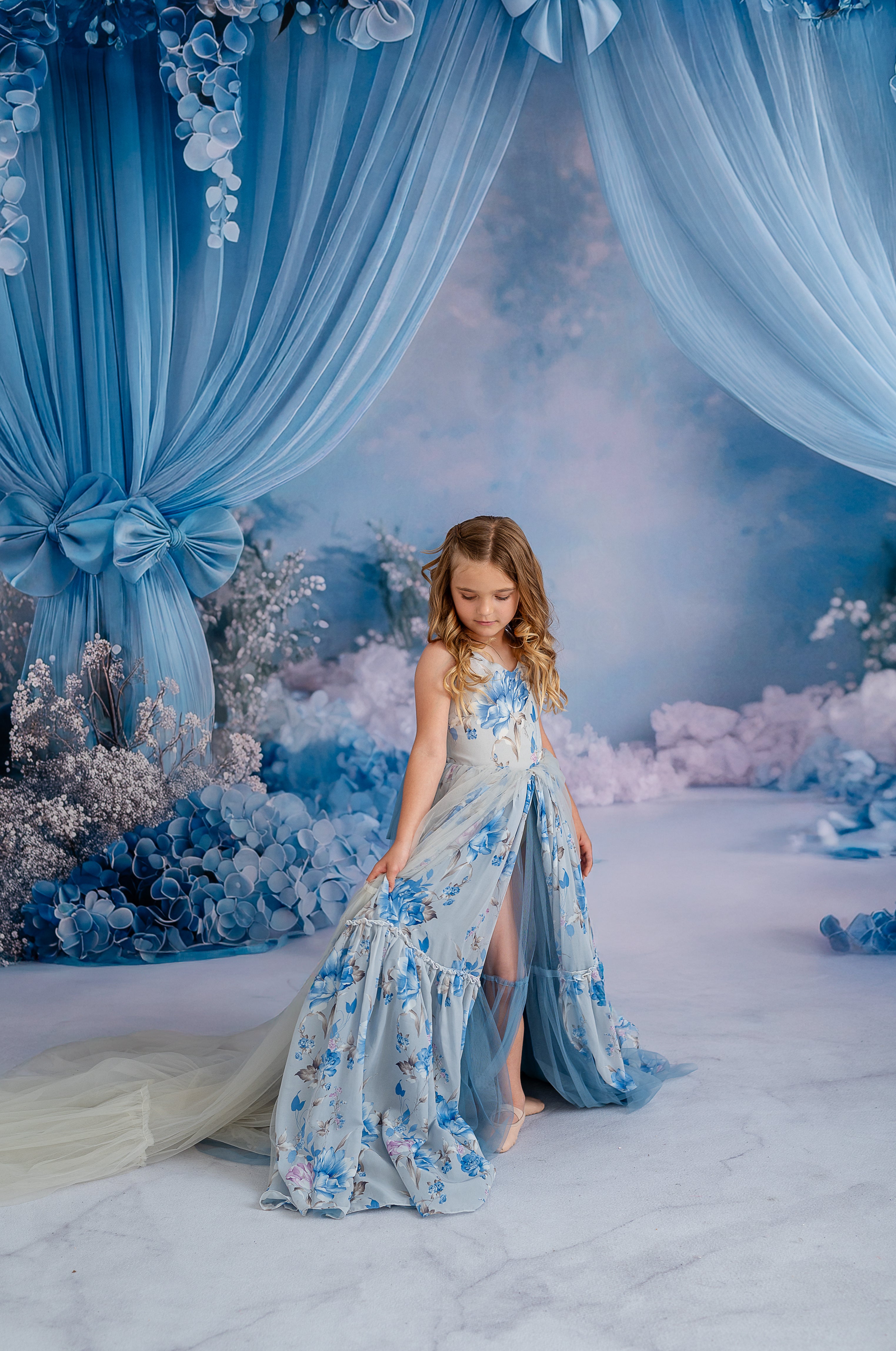 Child wearing Hillary solid couture gown in soft pastel tone with split front skirt.