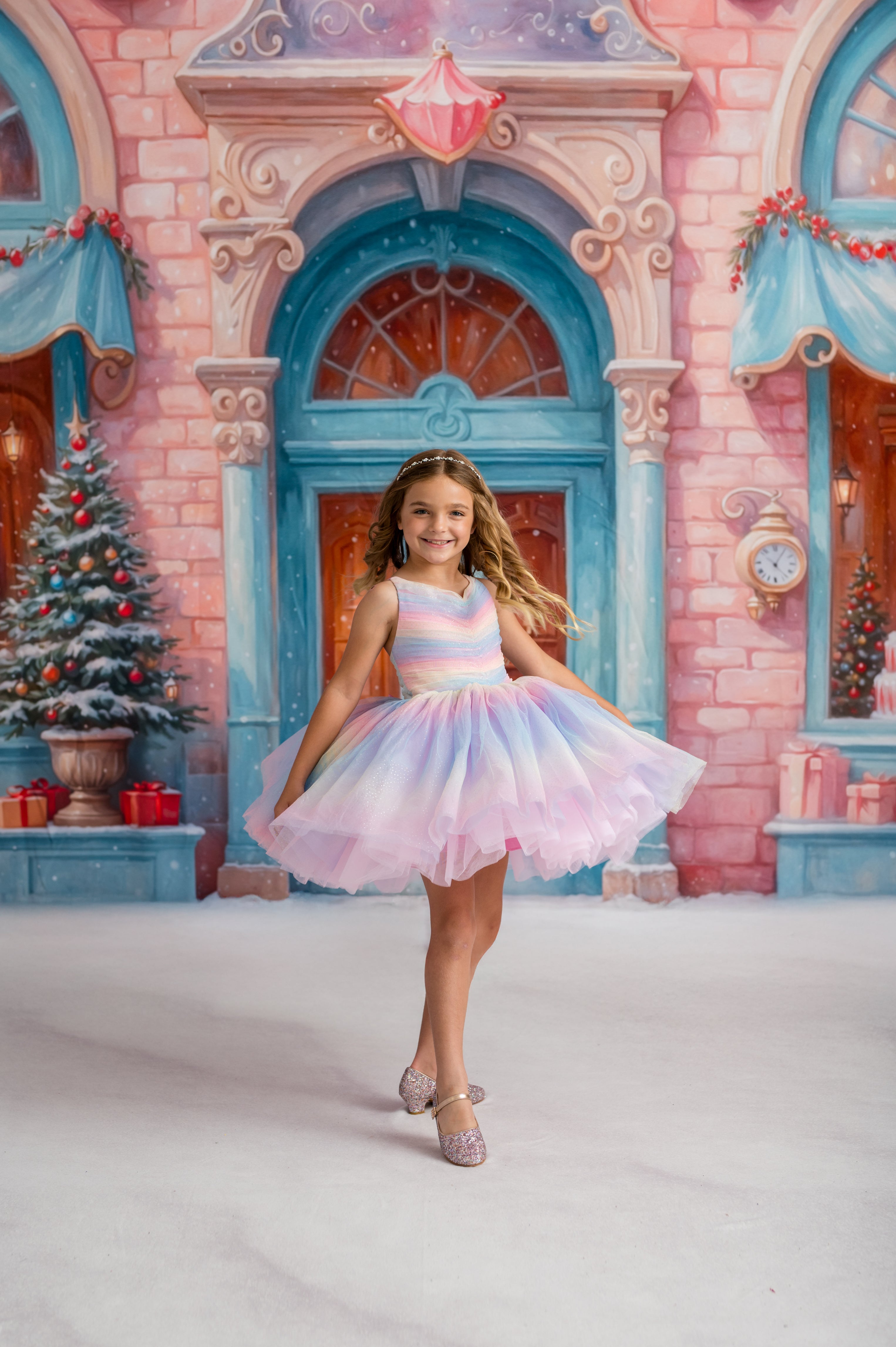 Young girl in a colorful dress standing in front of a festive castle background with Christmas decorations.