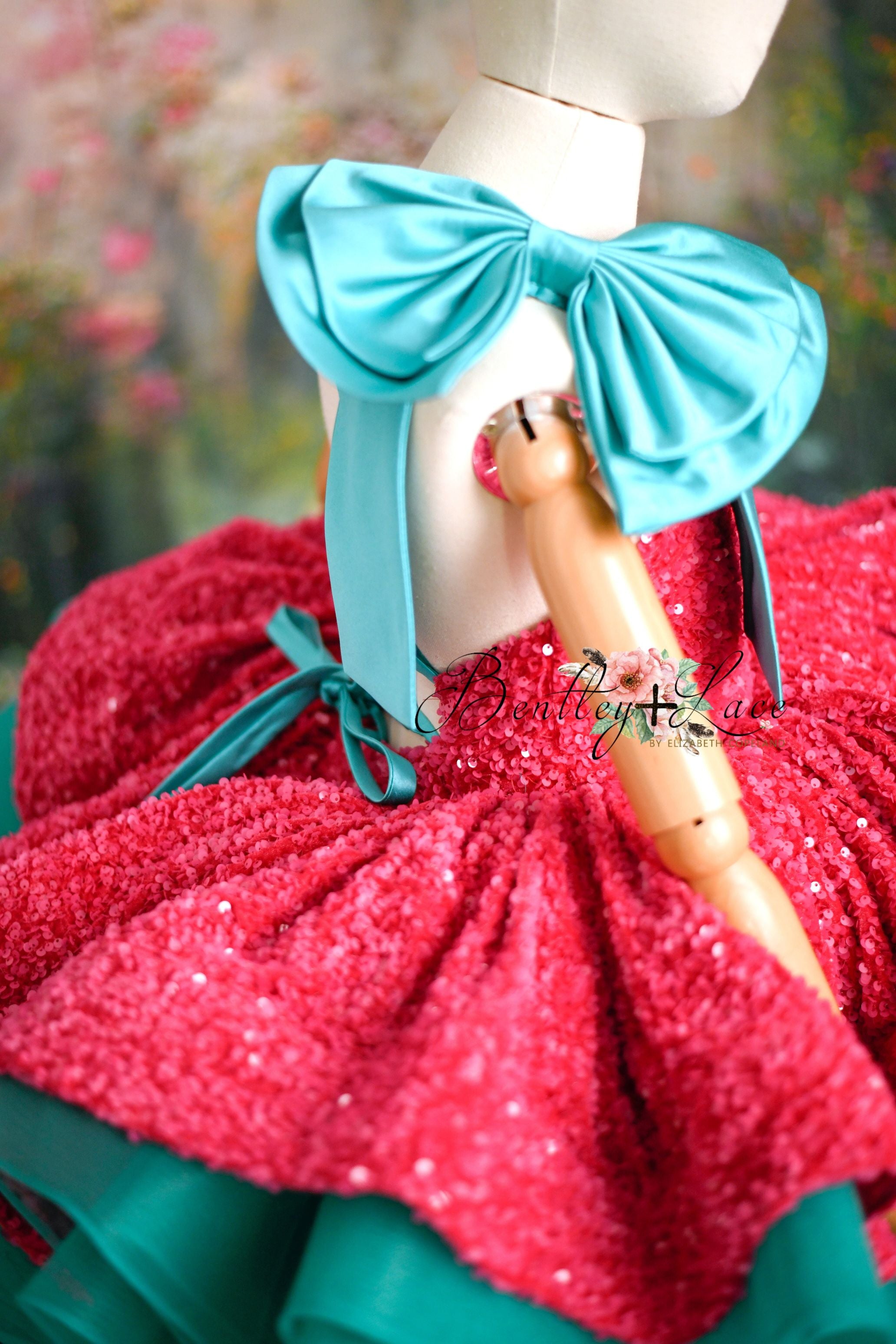 Side angle of little girl in shimmering pink and turquoise dress for holiday photos