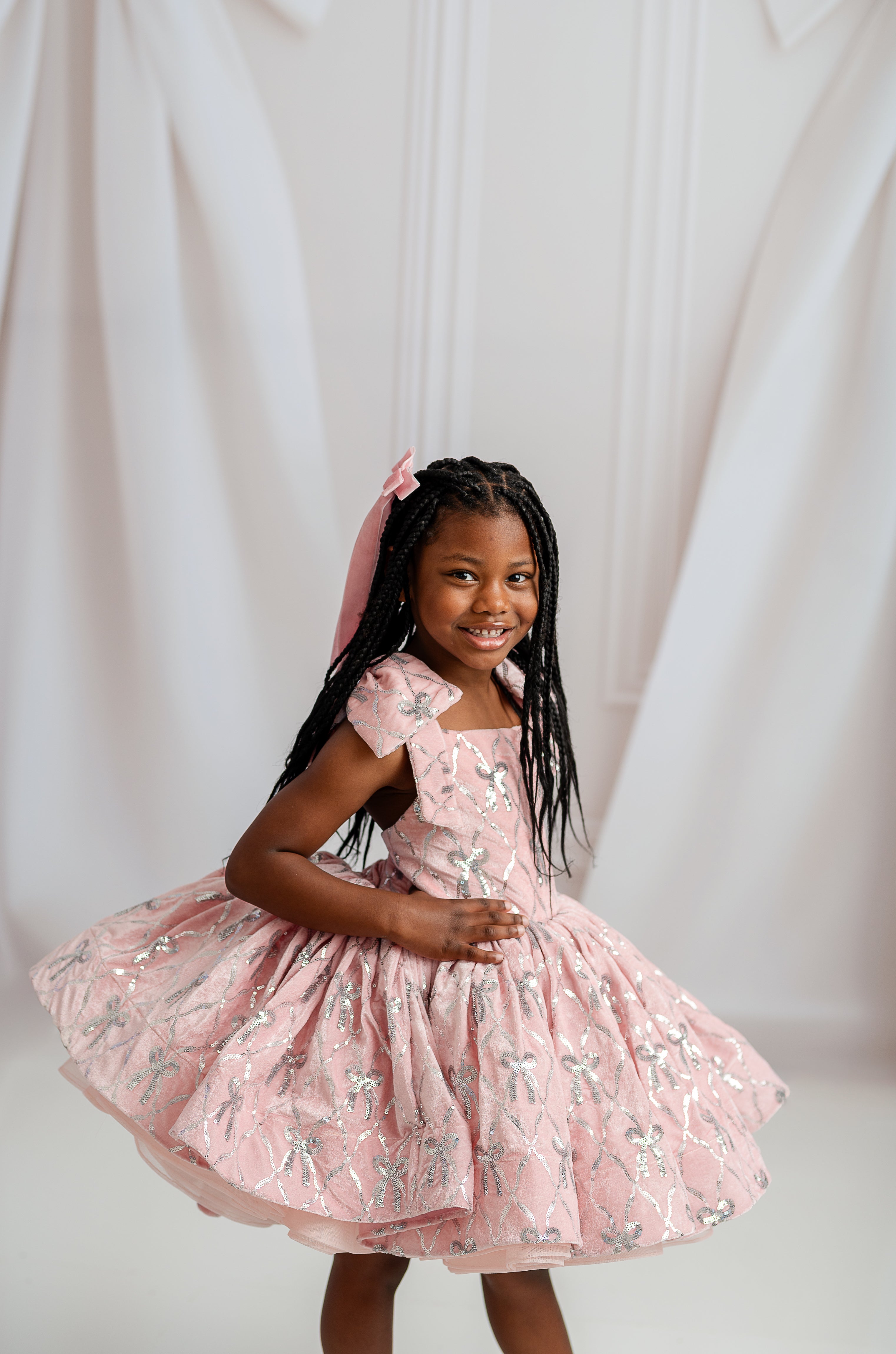 Child wearing Bentley + Lace couture gown with velvet top, satin bow, and elegant skirting.