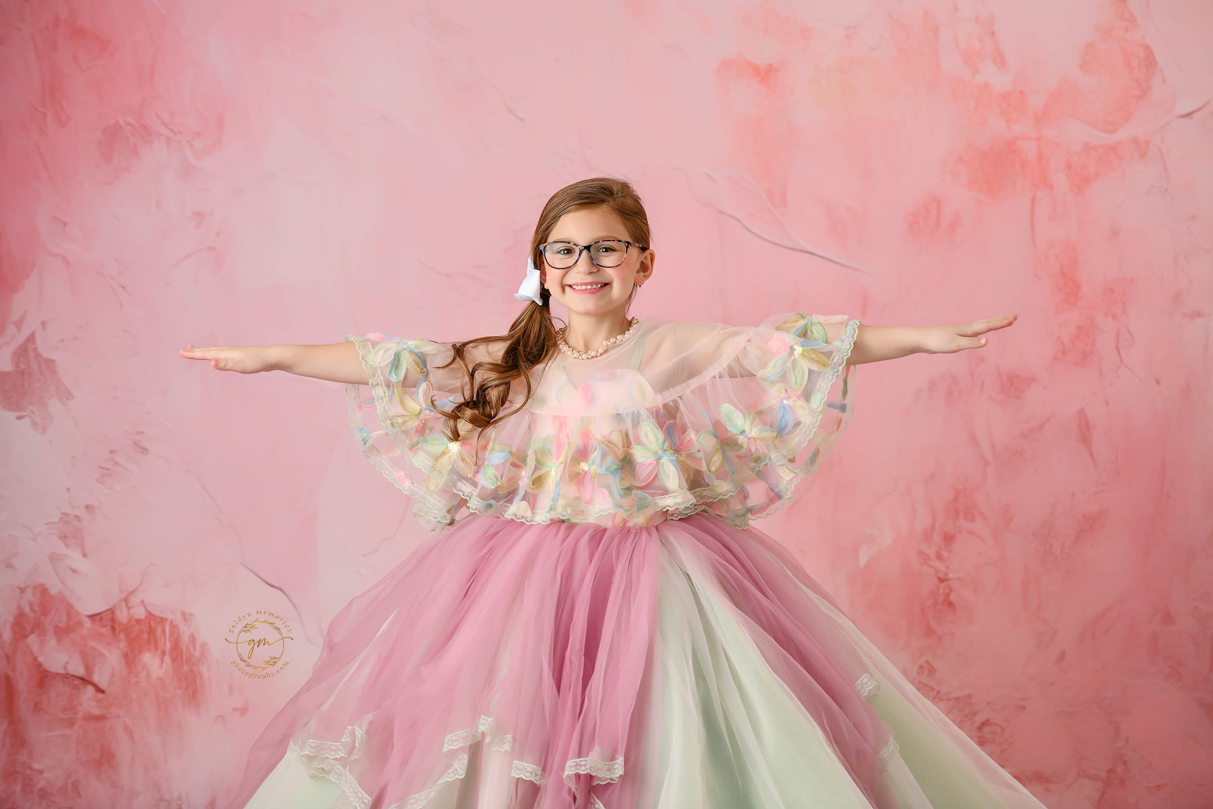 A young girl twirling in a breathtaking floral gown adorned with vibrant, intricate patterns.