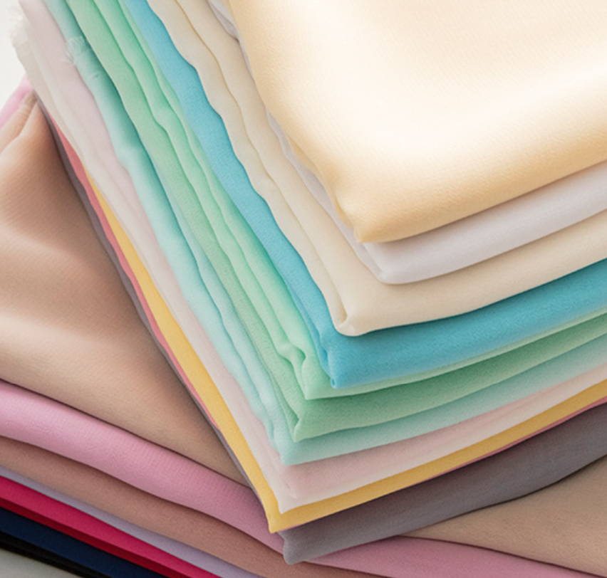 Stack of colorful fabric swatches in various pastel shades.