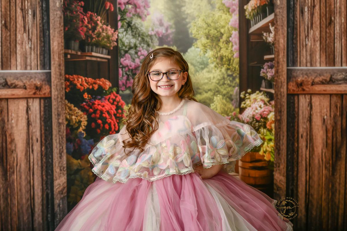 "Little girl twirling in a soft, flower-patterned dress with a full skirt."