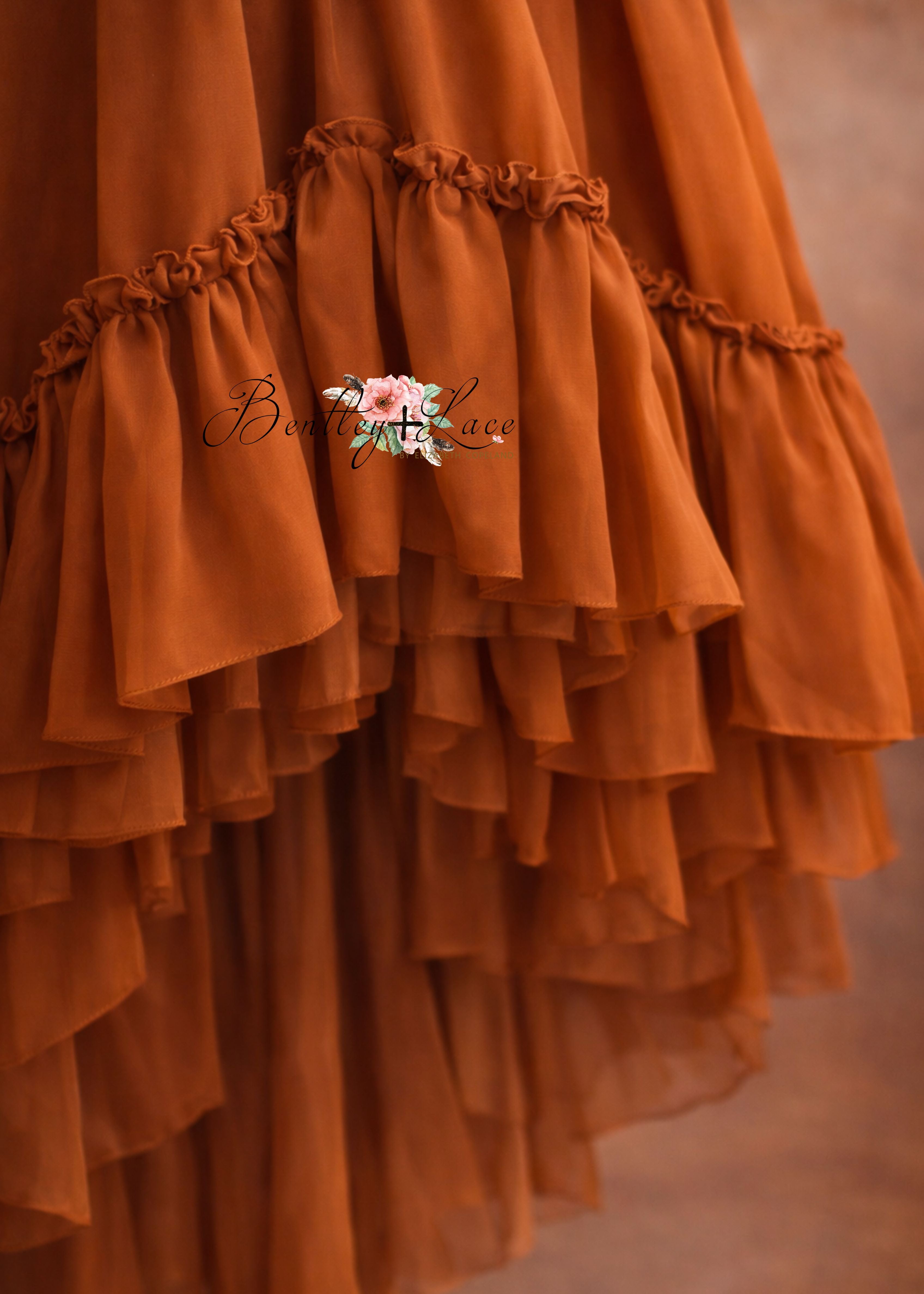 Orange ruffled fabric with a brand logo in the center.