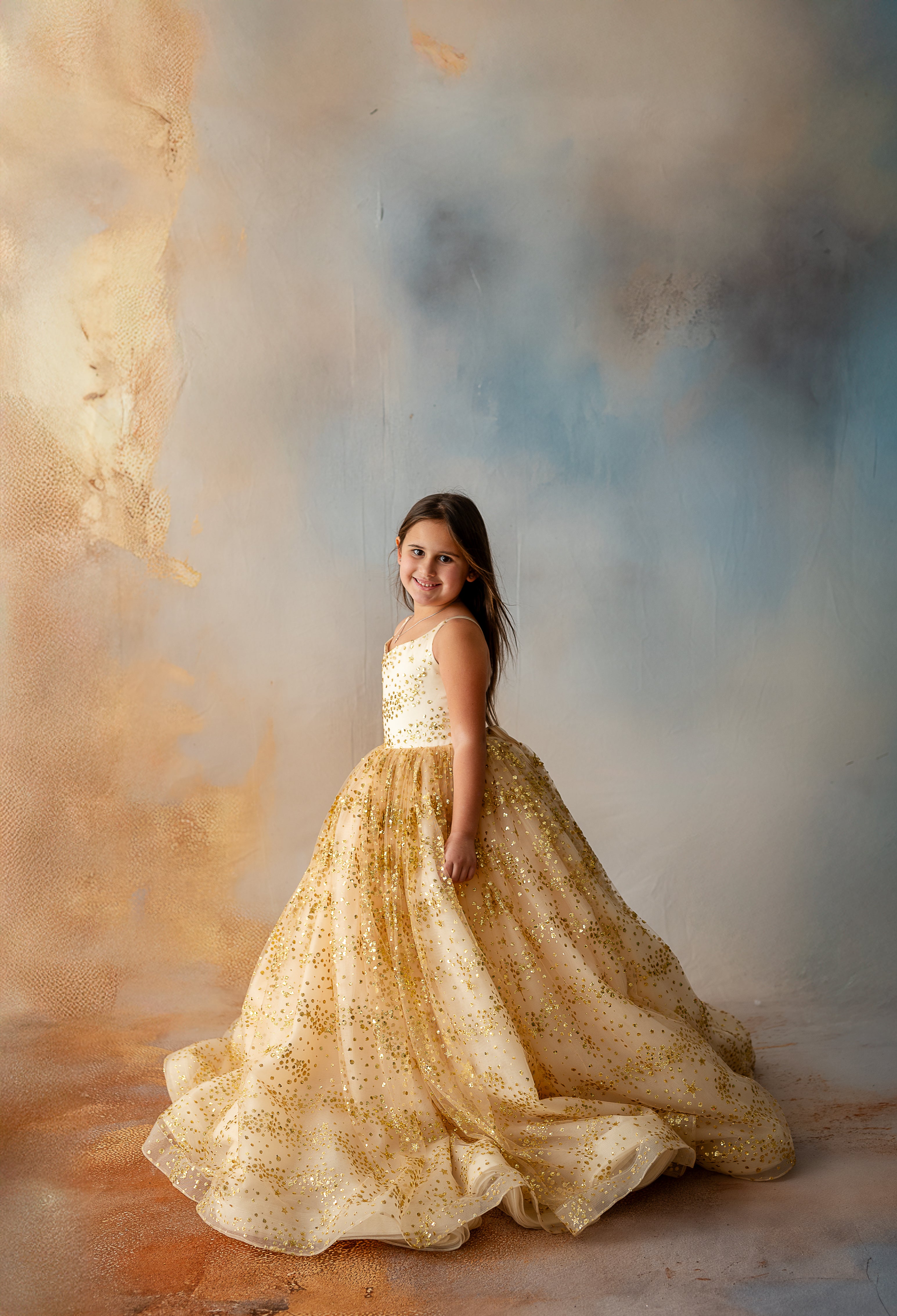 Side profile of child wearing sparkling gold tulle dress