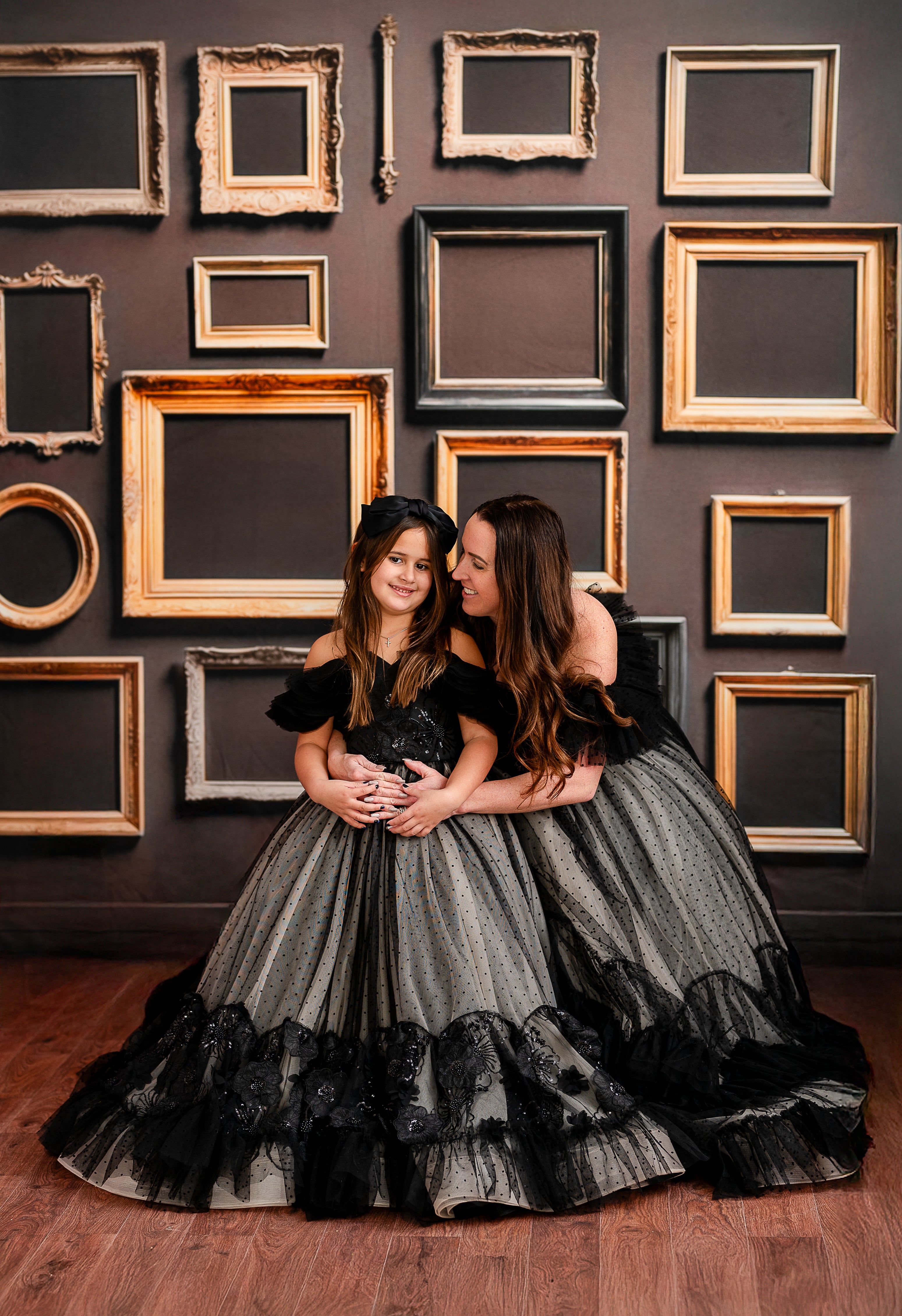 A stunning full-length gown styled against a backdrop of ornate empty frames.