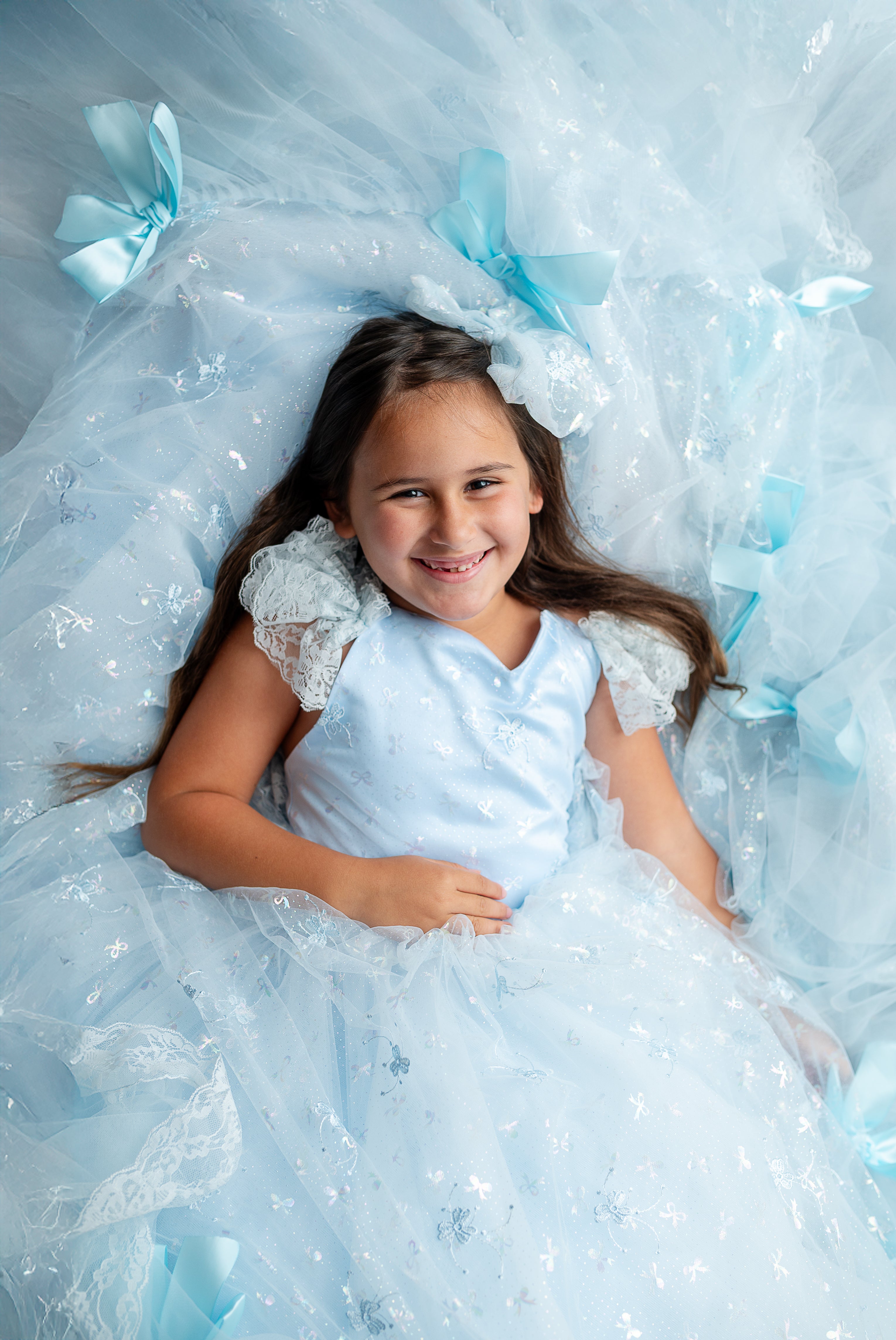 "Elegant couture gown with whimsical bow embellishments, styled for a dreamy photo shoot"