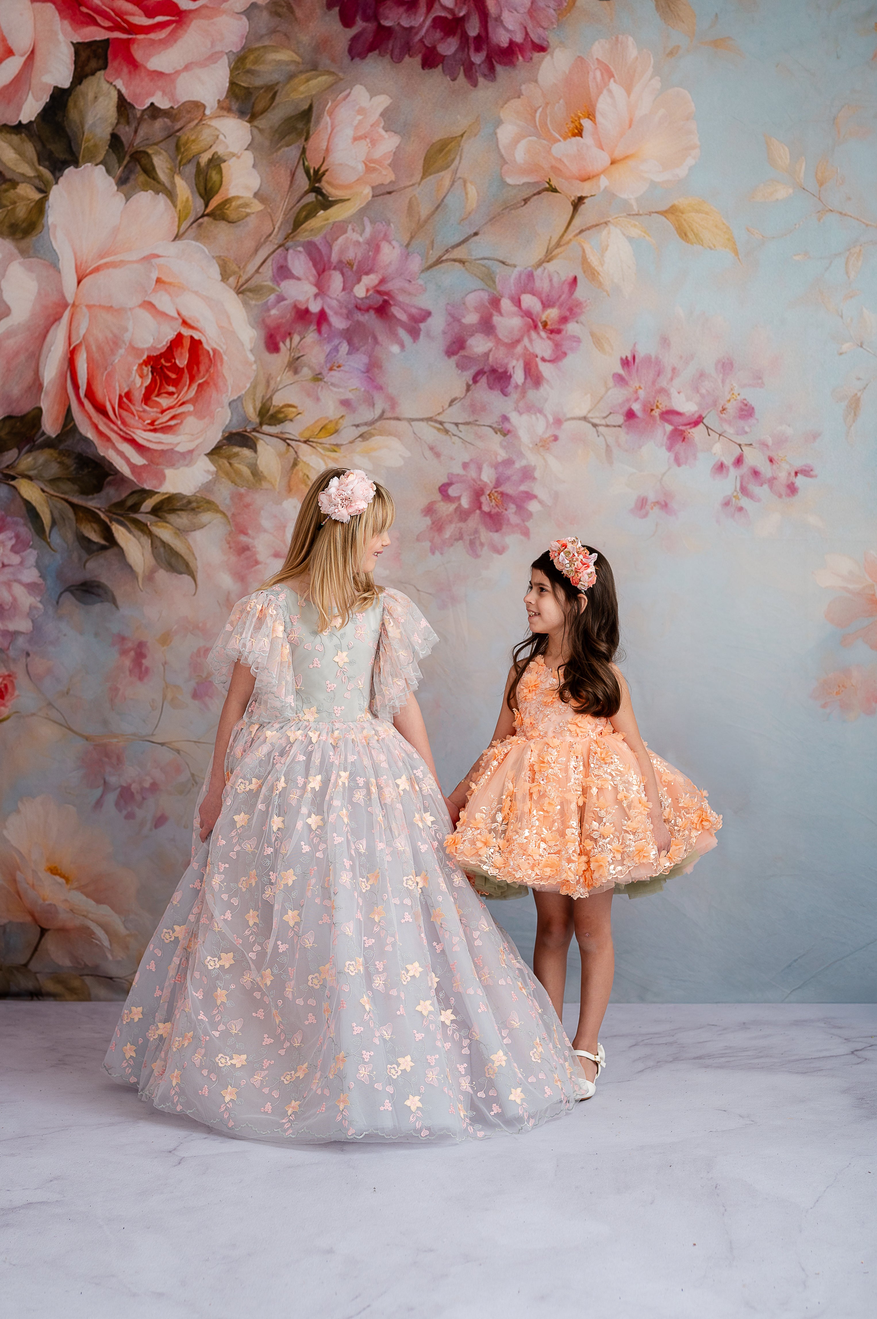 "Detailed view of the 'Peach Blossom' dress highlighting the elegant floral embroidery, gentle peach hues, and graceful petal-length skirt."