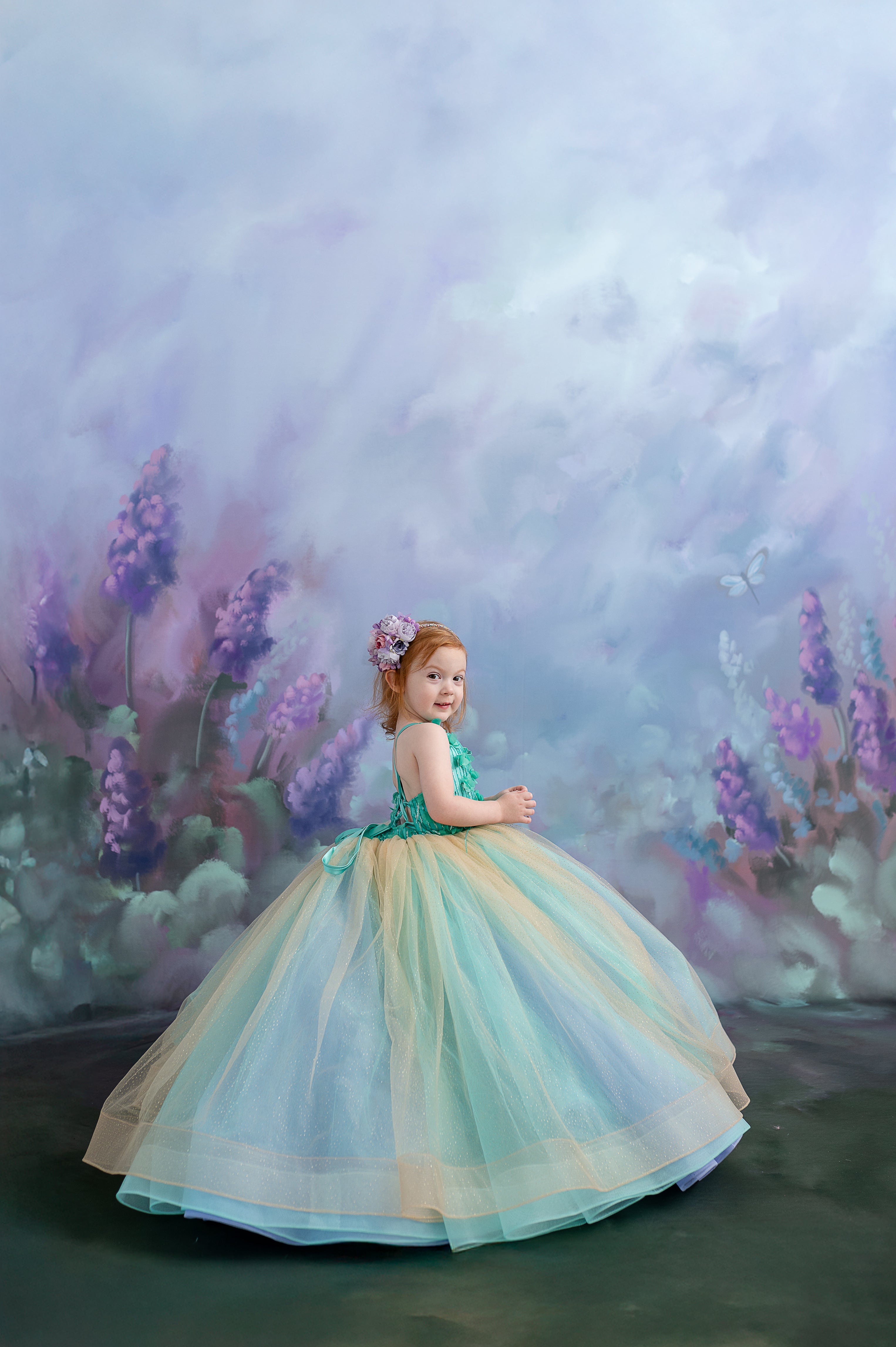 A little girl standing confidently in the gown, showcasing its stunning color combination and volume.