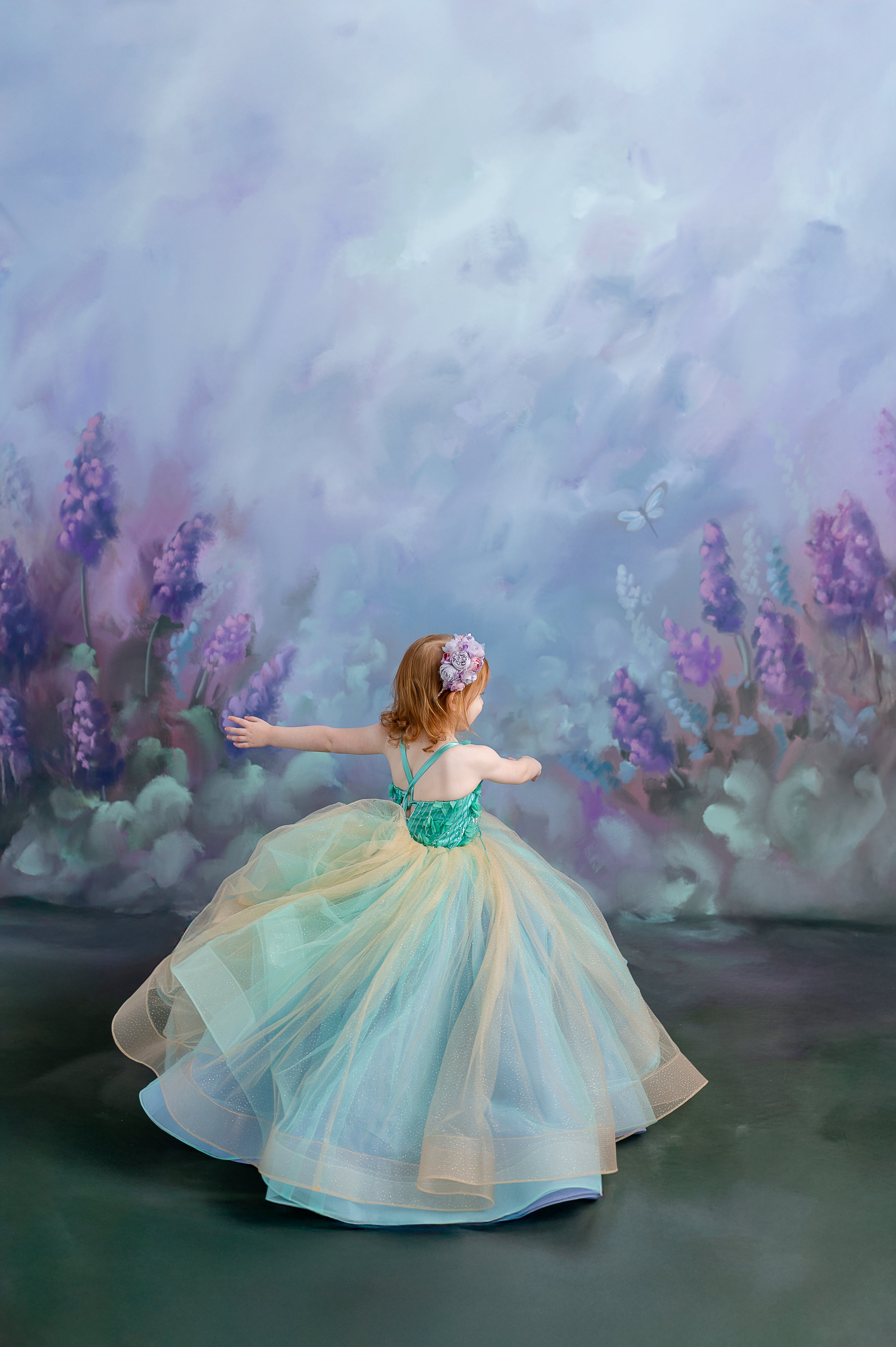 A playful twirl – young girl spinning in the Evelyn gown, showing off its flowing silhouette.