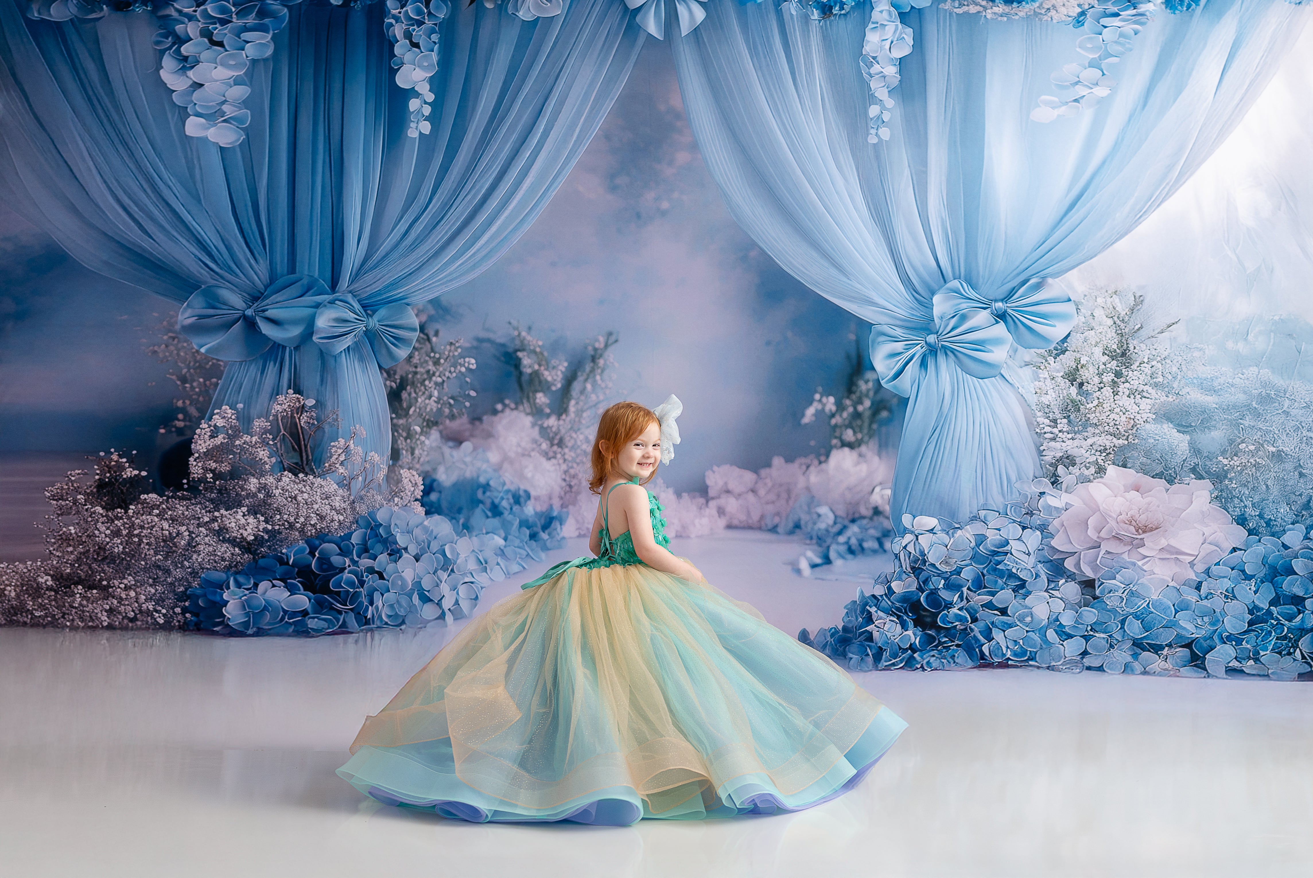 Back view of the gown highlighting adjustable shoulder straps and the cascading layers of soft tulle.