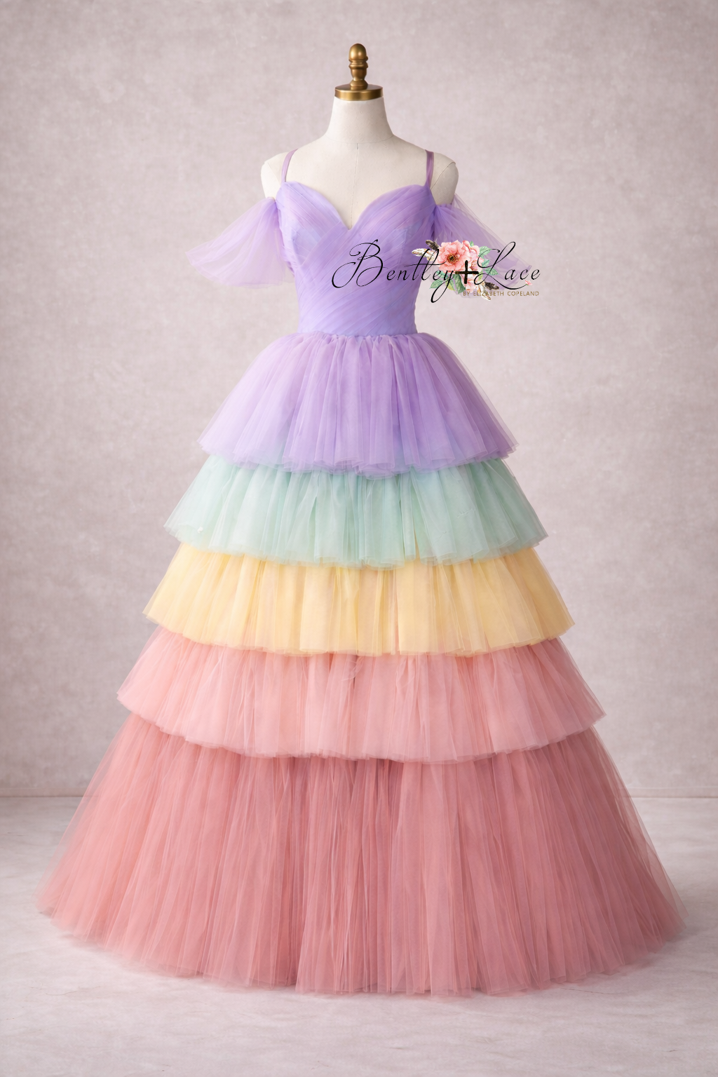 Pastel rainbow tiered dress on a mannequin against a plain background