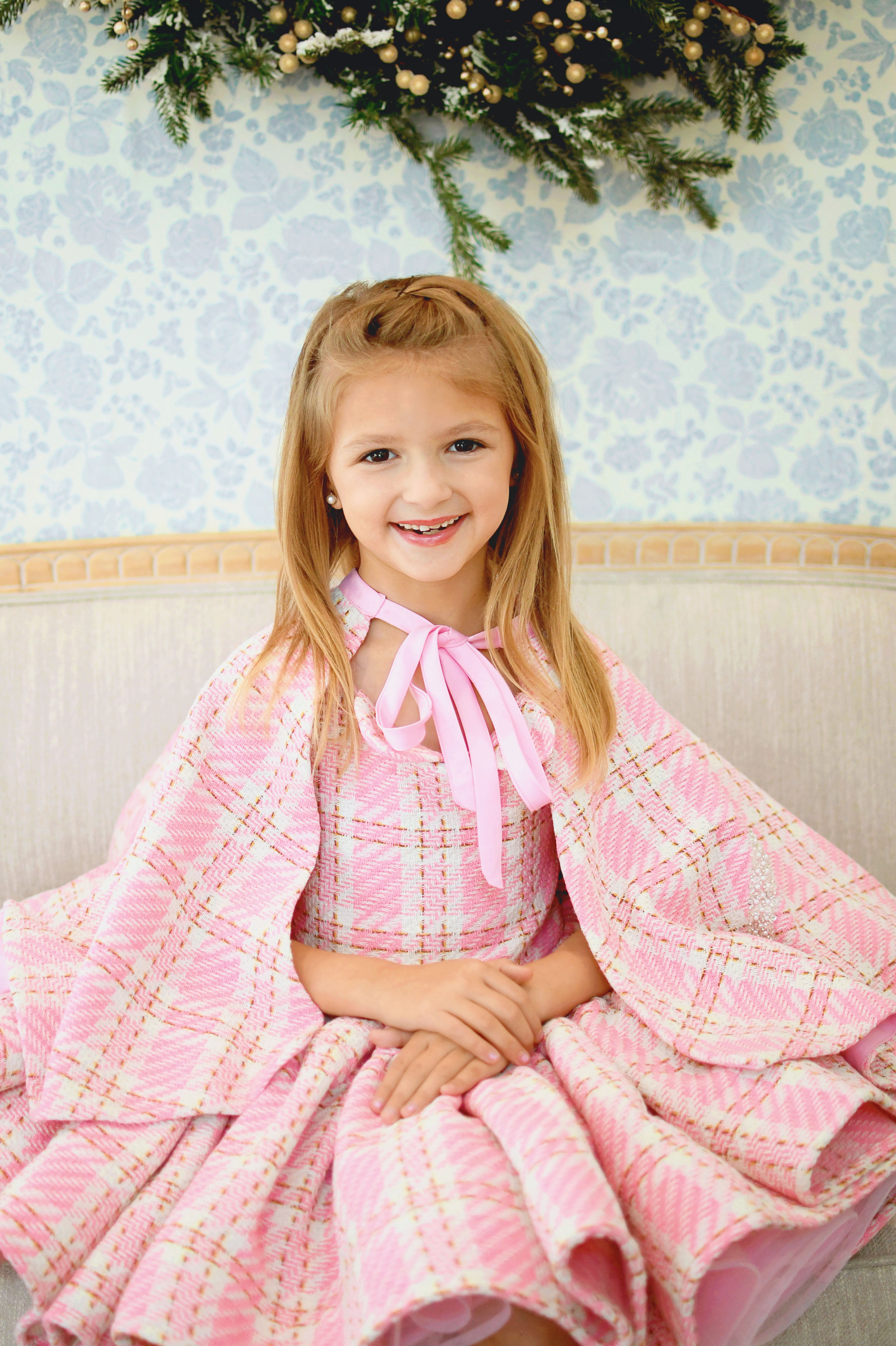 Elegant pink wool plaid dress worn by a girl, featuring soft fabric and classic design.