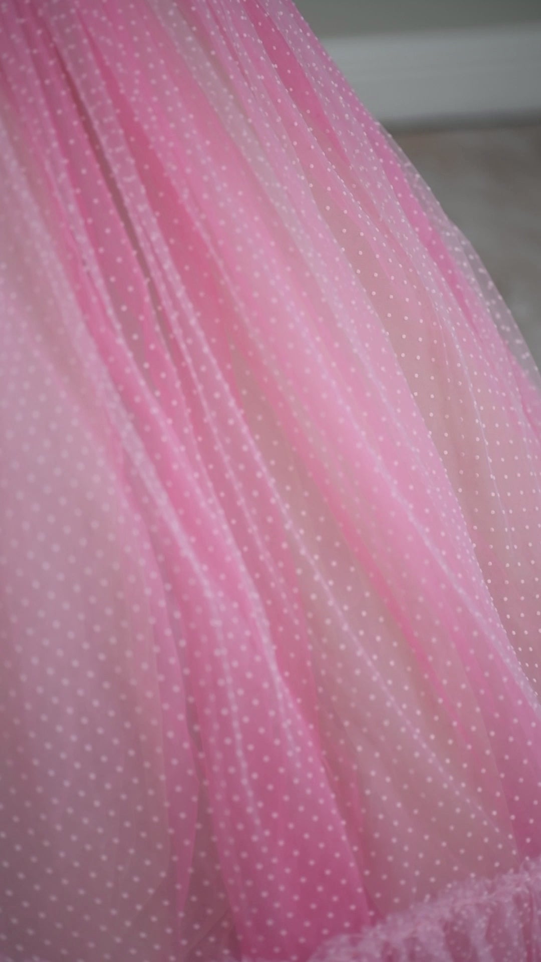 "The Swish Dot Couture gown’s soft pink Swiss dot fabric paired with delicate pastel layers, creating a perfect balance of elegance and charm."
