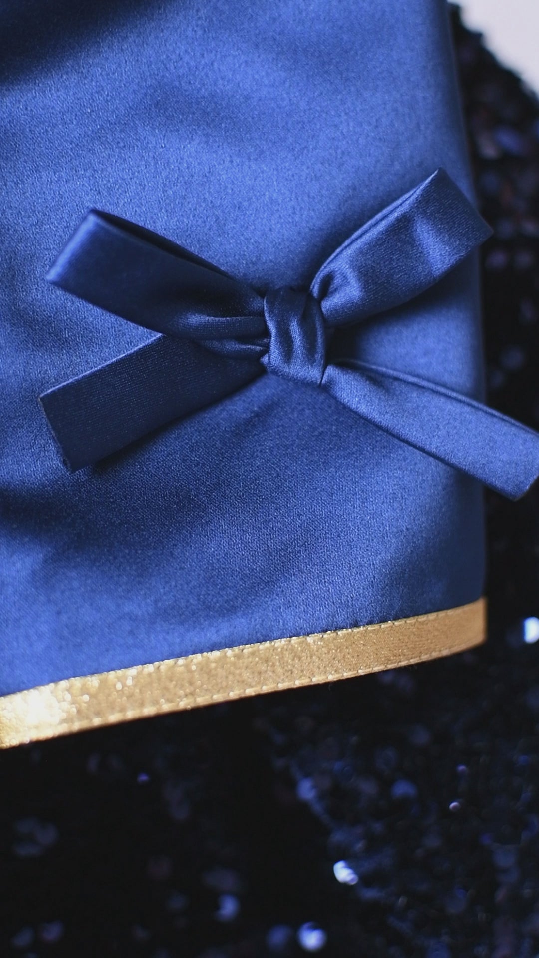 Sleeve close-up with satin bow and gold trim on Polar Express–inspired dress