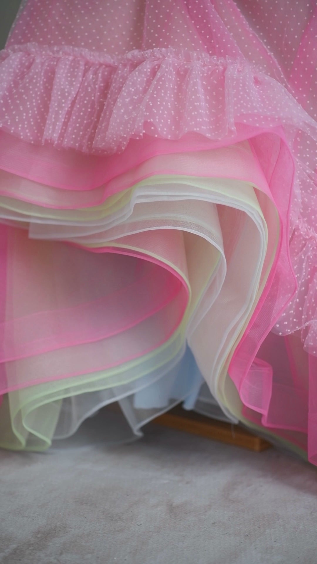 "Model wearing the Swish Dot Couture Pastel gown, capturing the light and beauty of its layered skirt and adjustable fit."