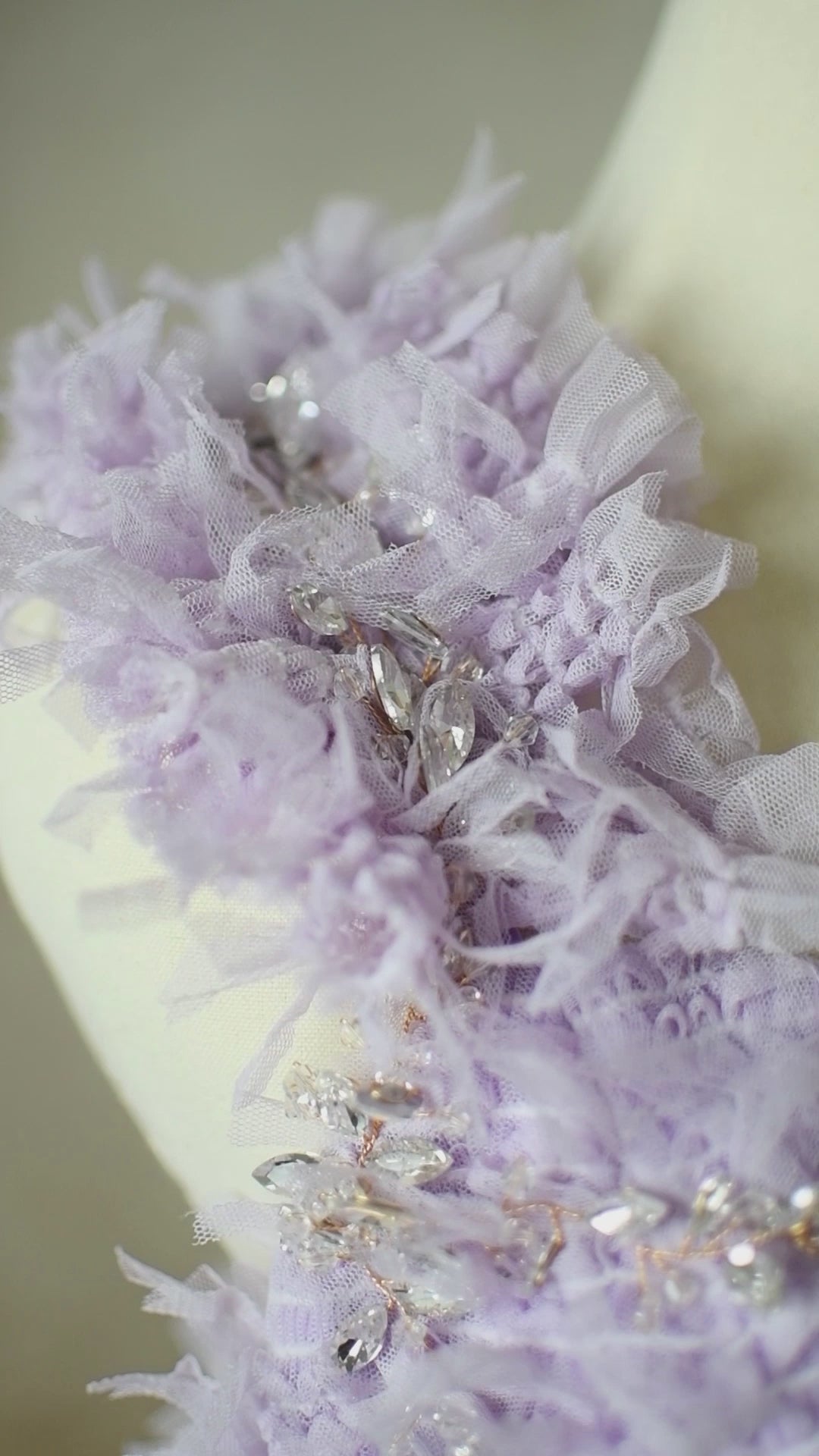 Elegant lavender gown with rhinestone neckline details and flowing fabric.