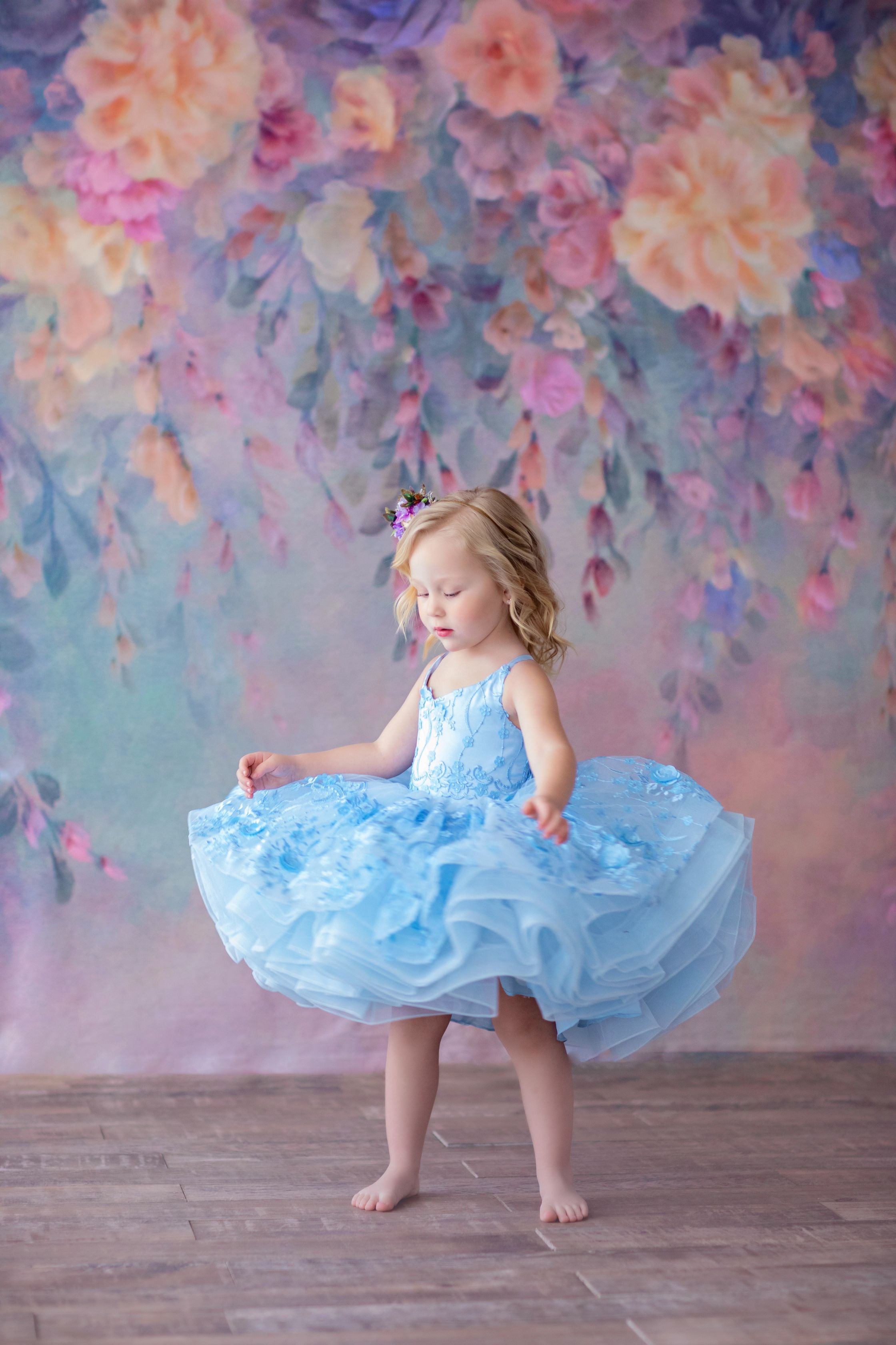Close-up of the Heavenly gown’s soft blue 3D floral fabric and layered tulle skirt, showcasing delicate texture and feminine charm.