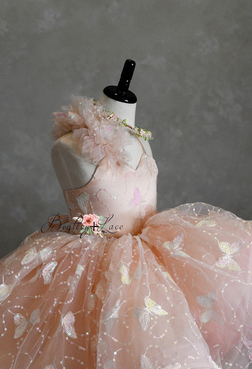 "Side profile of the Anastasia gown, featuring adjustable shoulder ties and an elastic back for a customizable fit."