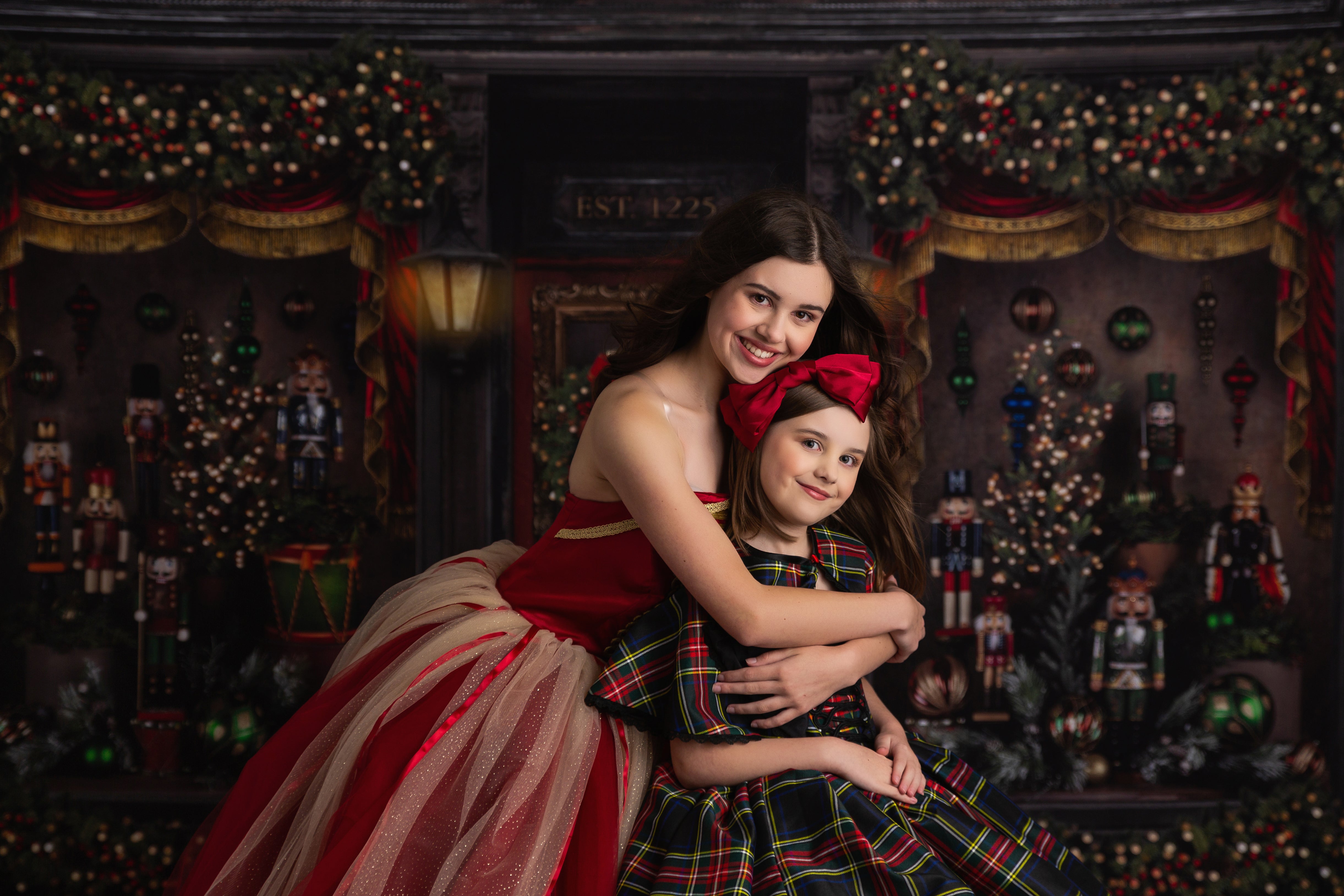 Child posing in red Nutcracker princess gown with holiday backdrop