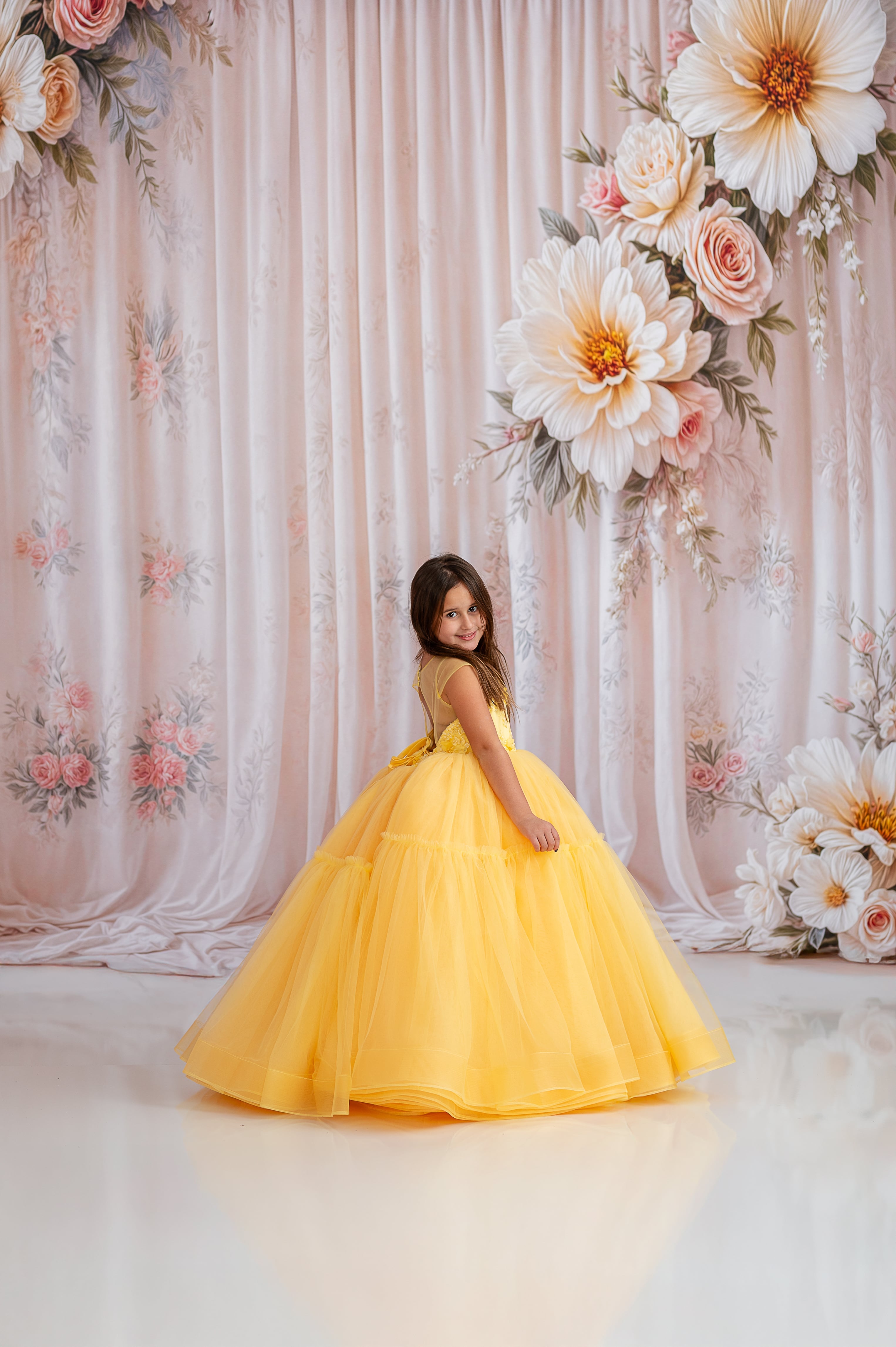 Young girl radiating elegance in a stunning yellow gown.