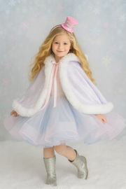 Young girl in a fairy costume with a pink hat and white fur trim on a light gray background