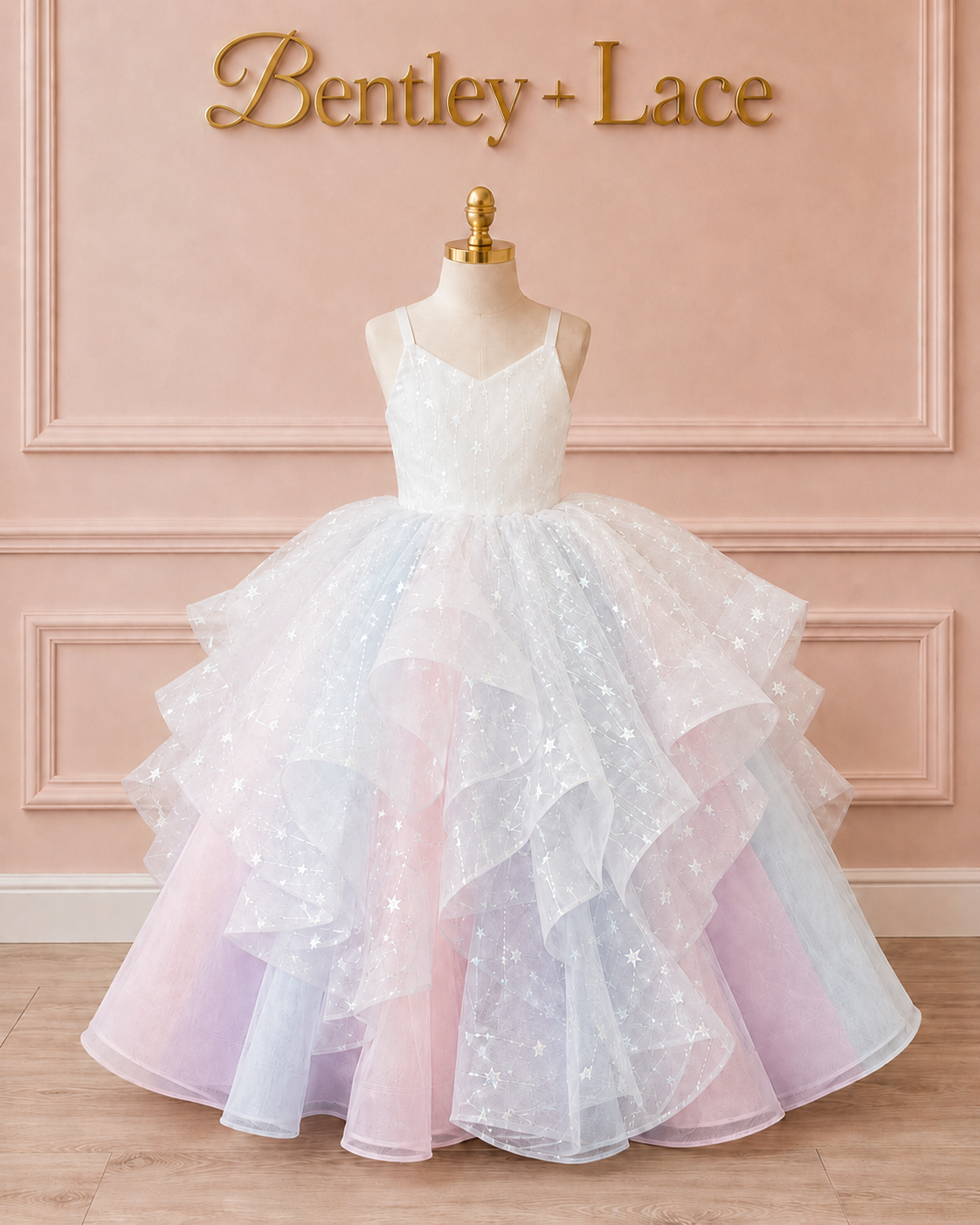 White and pink tiered dress on a mannequin against a pink wall with 'Bentley + Lace' branding.
