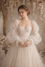 Woman wearing a elegant white wedding dress with sheer sleeves in a floral setting
