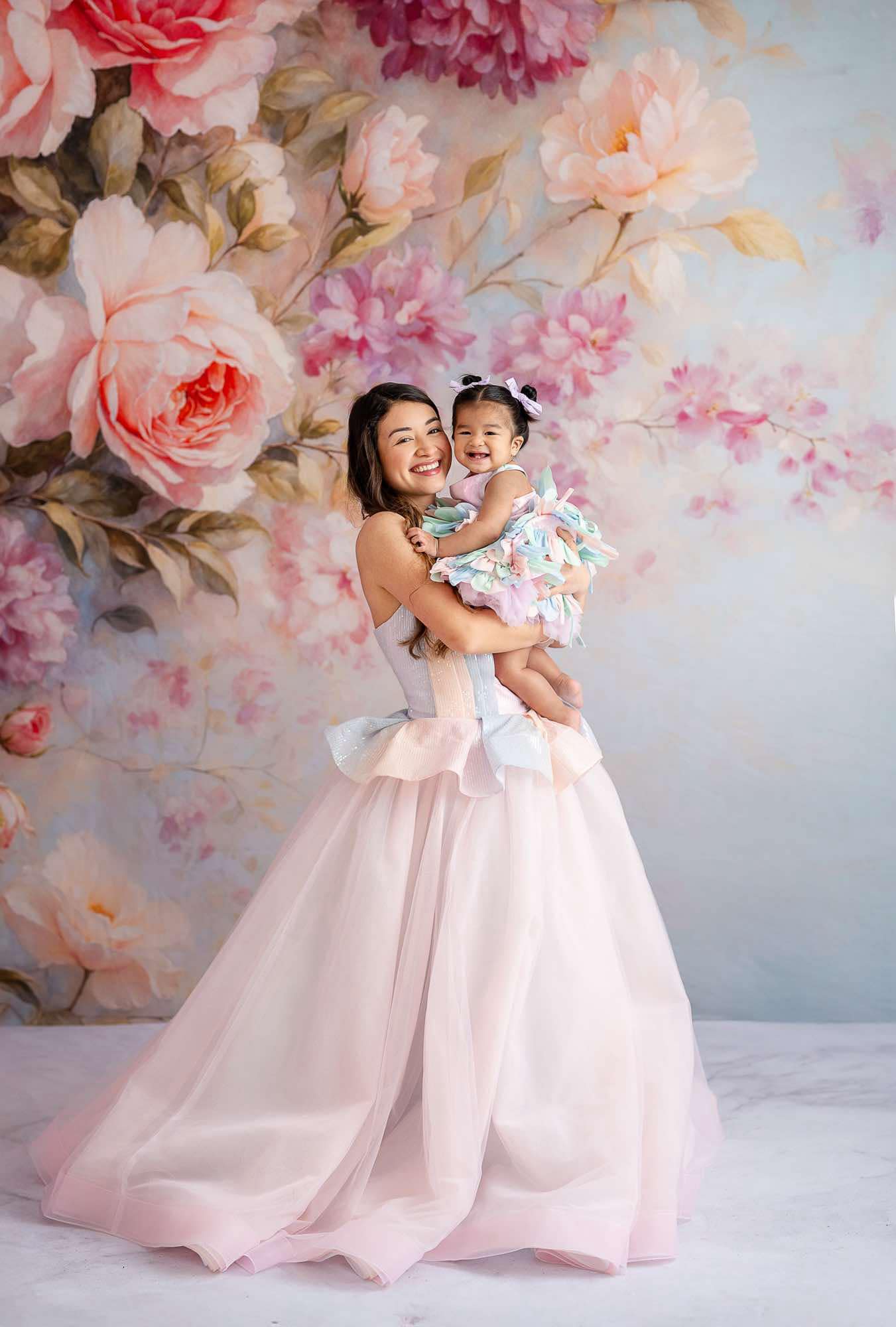 Mommy and Me gowns in soft pastel hues, featuring a graceful petal dress and matching styles, beautifully posed against a delicate floral backdrop, perfect for capturing timeless mother-daughter moments.