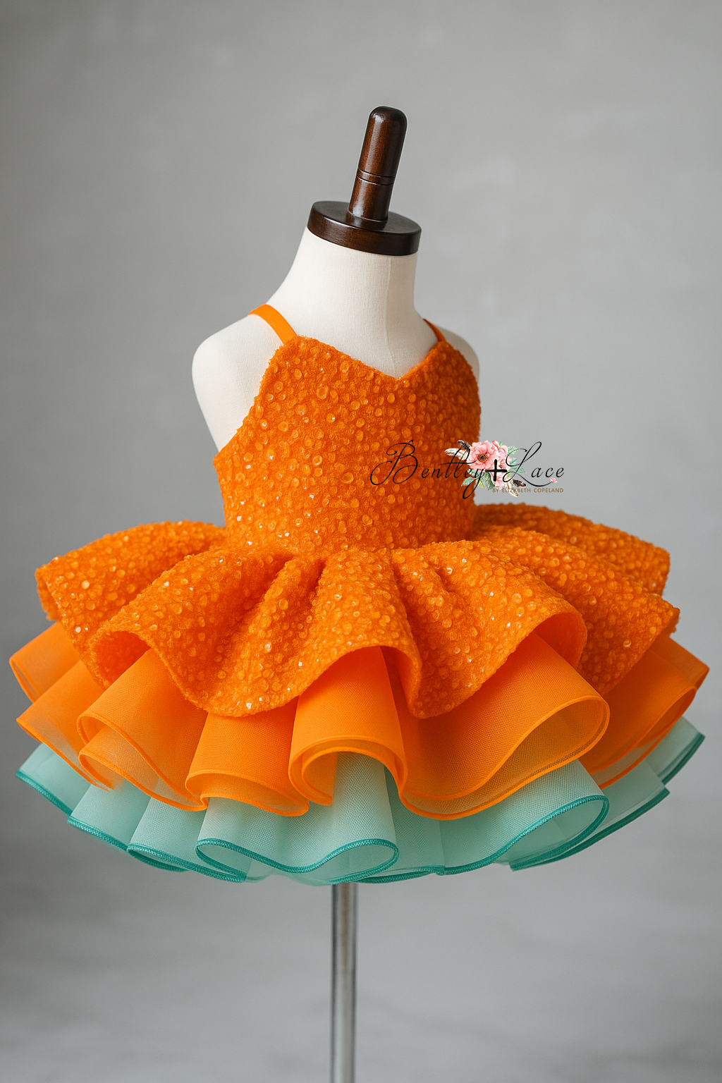 Orange and green dress on a mannequin against a gray background