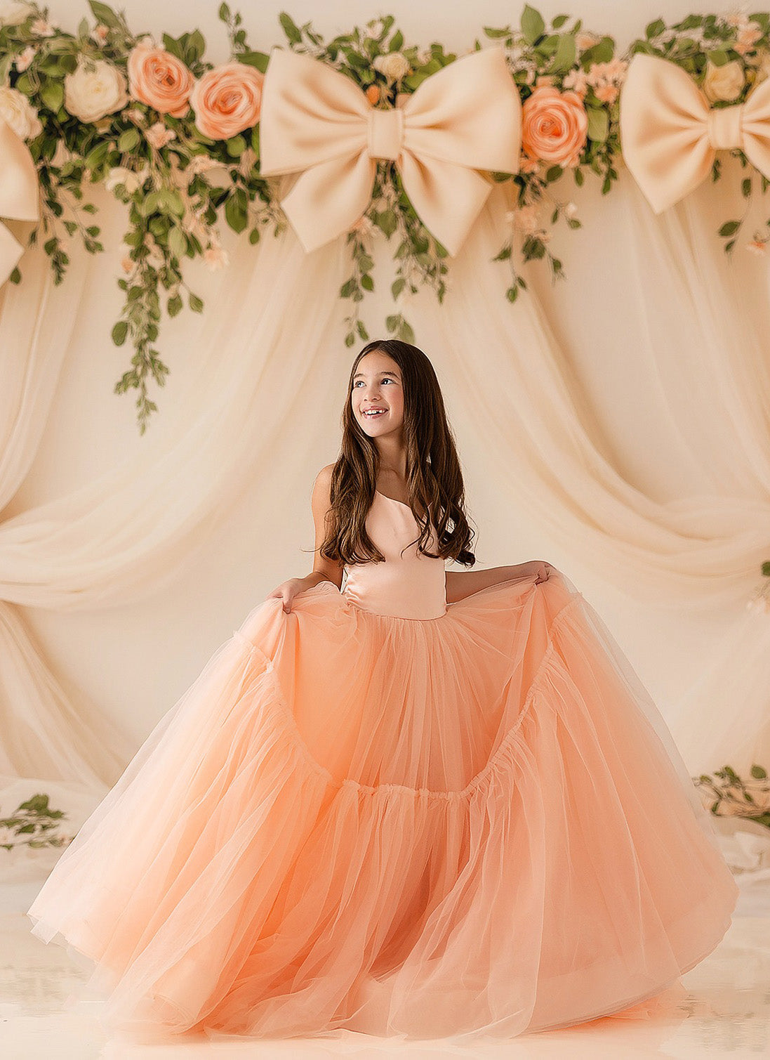 "Full-length peachy pink gown with flowing tulle skirt on dress form"

