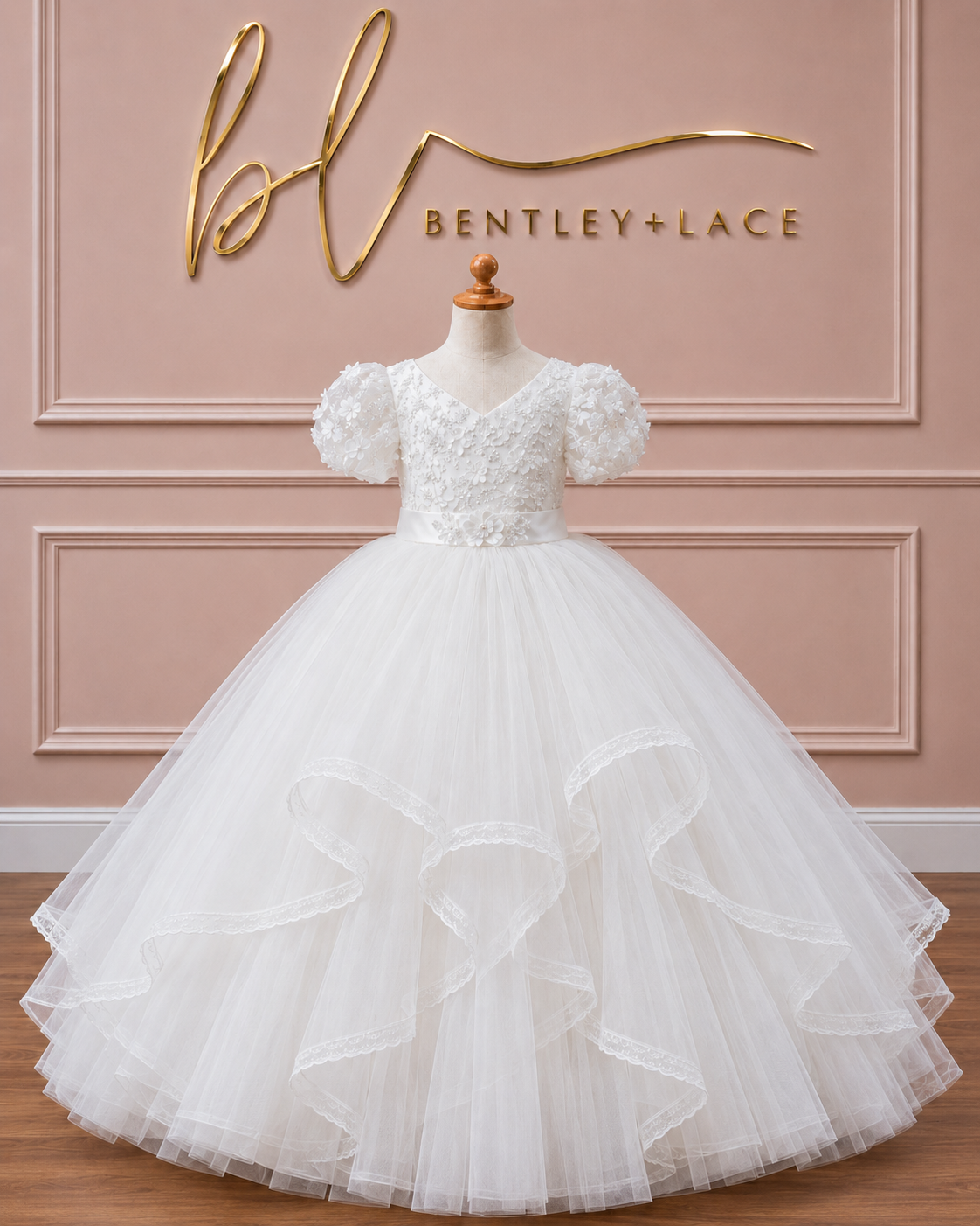 White lace dress on a mannequin against a pink wall with 'Bentley + Lace' branding.