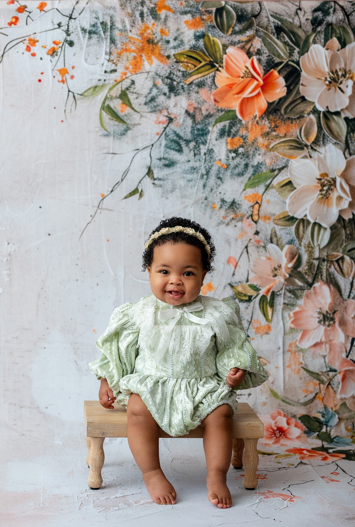 Sage heirloom baby romper featuring delicate lace trim, gathered silhouette, and vintage-inspired bishop sleeves in soft velvet fabric.

