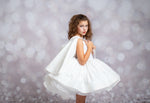 Young girl in a white dress against a blurred background