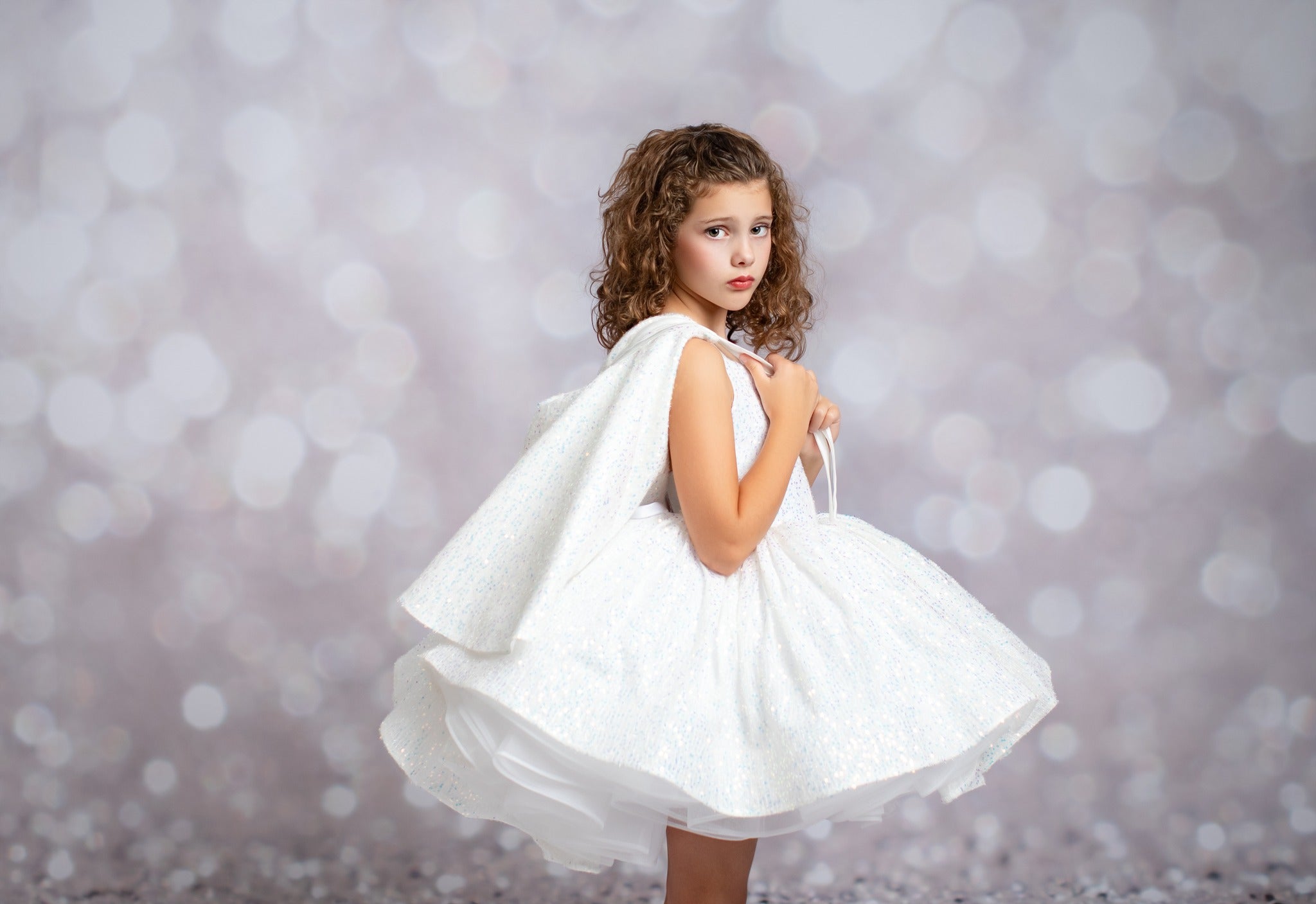 Young girl in a white dress against a blurred background