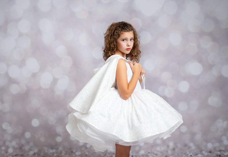 Young girl in a white dress against a blurred background