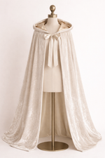 White lace cape on a mannequin against a plain background