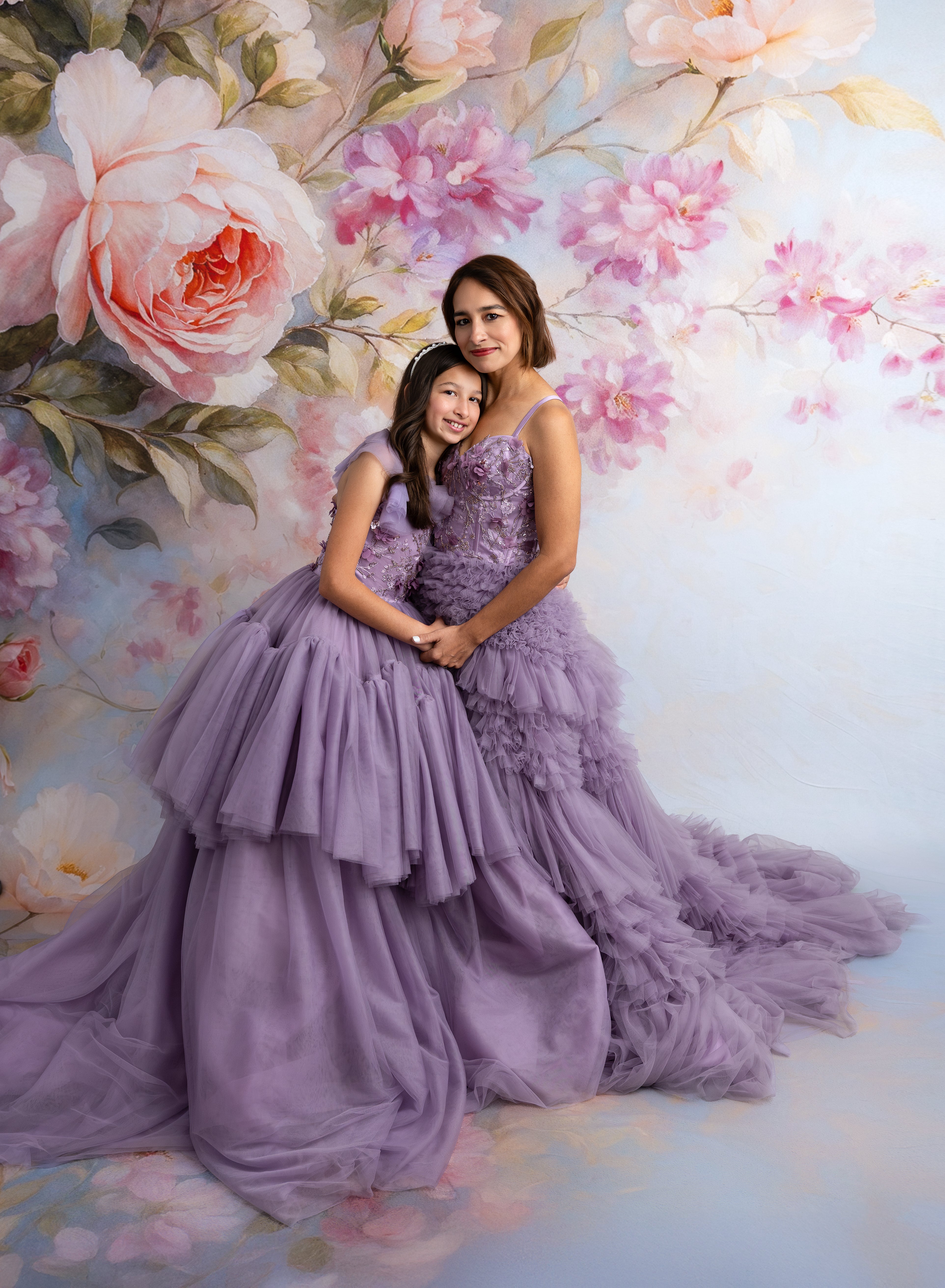 Mother and daughter wearing matching Violet Grace gowns in soft violet tones

