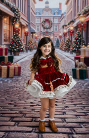 A young girl stands on a cobblestone street wearing a festive red and white holiday dress with brown boots, surrounded by decorated Christmas trees, gift boxes, and warm streetlights in the background.