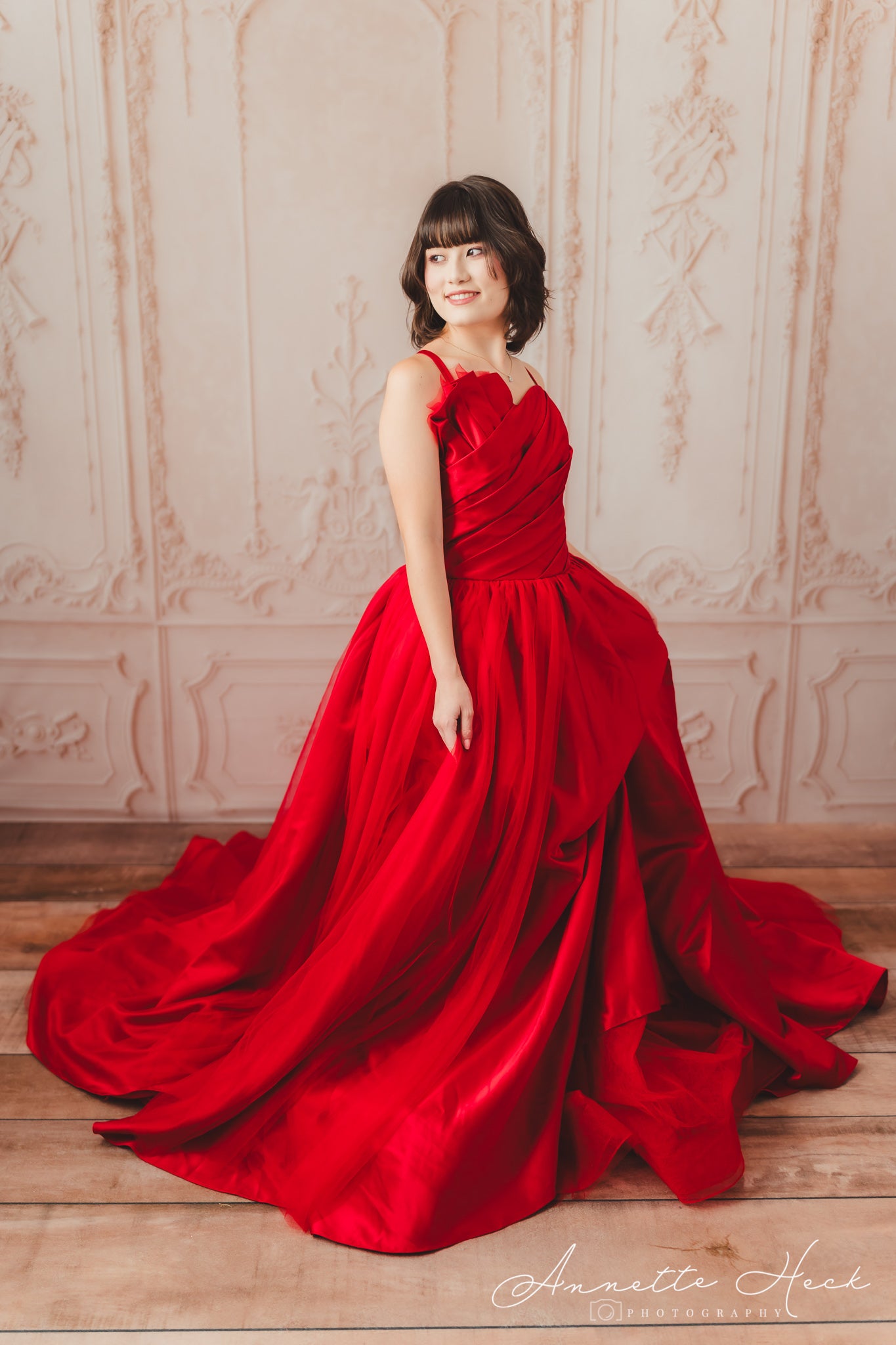 Bold red satin gown with a sleek silhouette and a high slit for a touch of glamour.