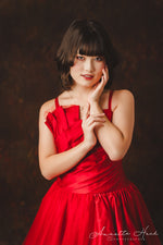 Stunning red satin dress featuring a fitted bodice and a dramatic train.