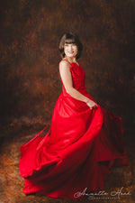 Luxurious red satin evening gown with a sweetheart neckline and intricate draping.