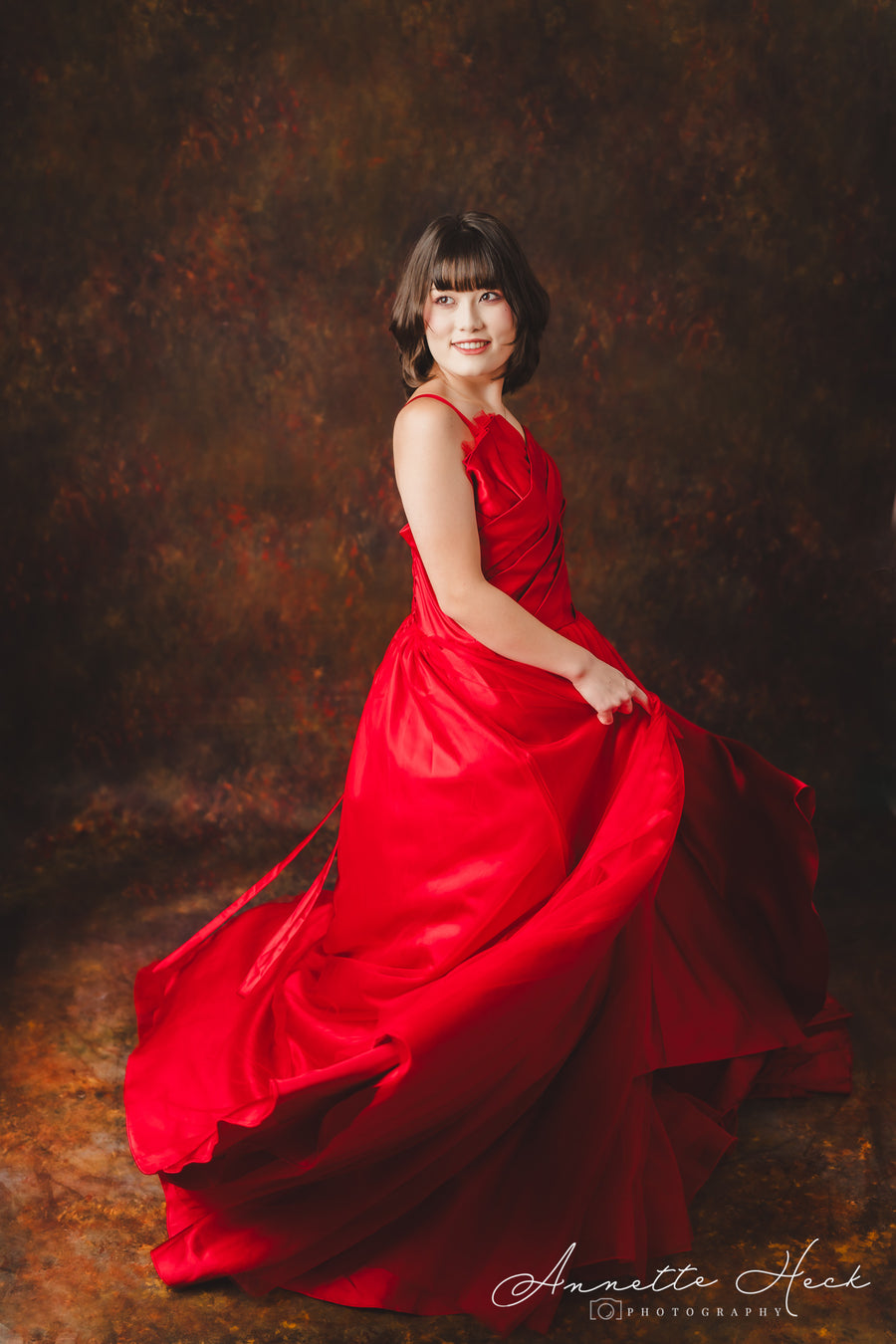 Luxurious red satin evening gown with a sweetheart neckline and intricate draping.
