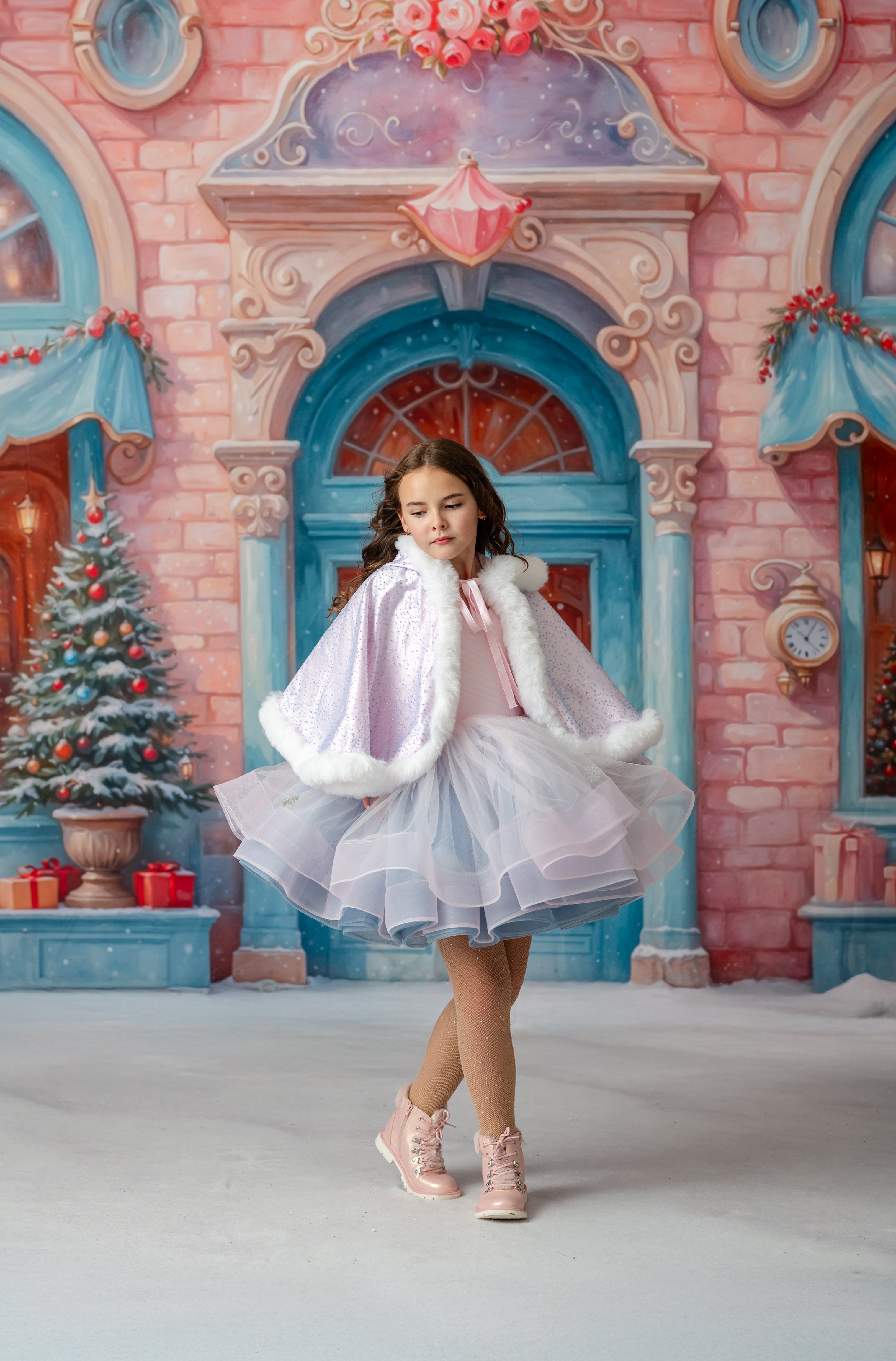Young girl in a white dress with fur trim standing in front of a festive building with Christmas decorations.