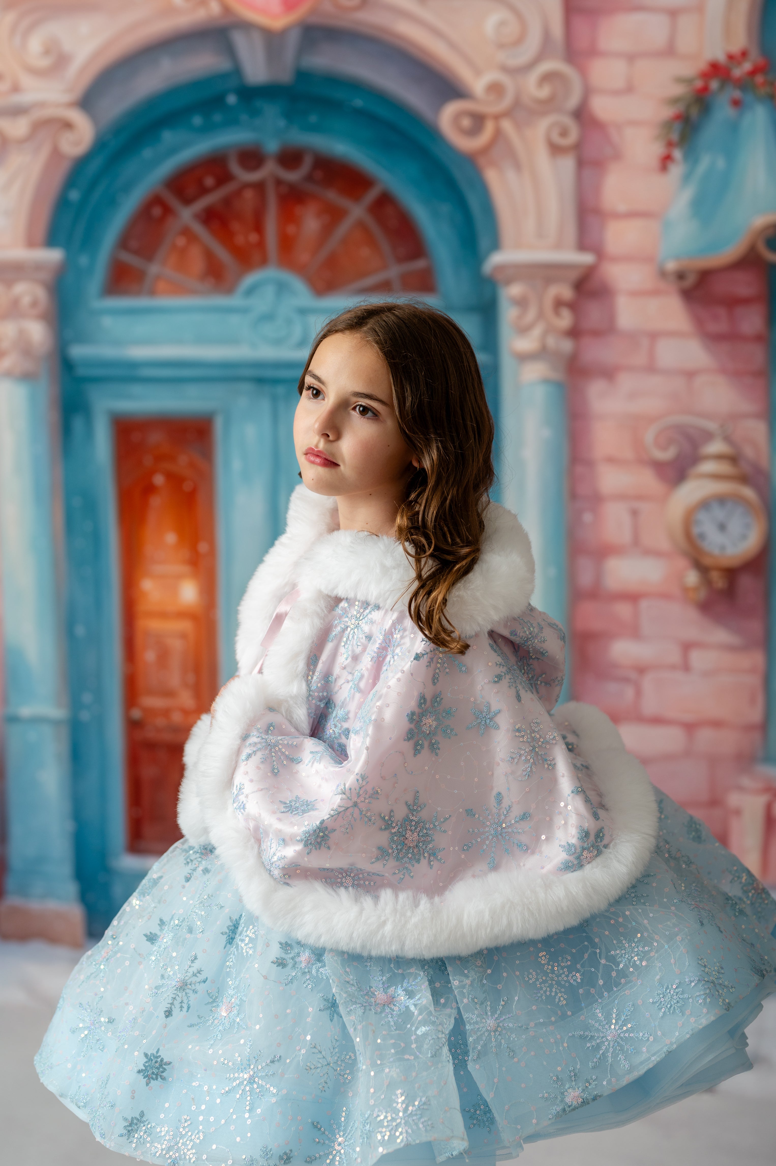 Young girl in a winter dress with snowflake patterns against a fairy-tale castle background.