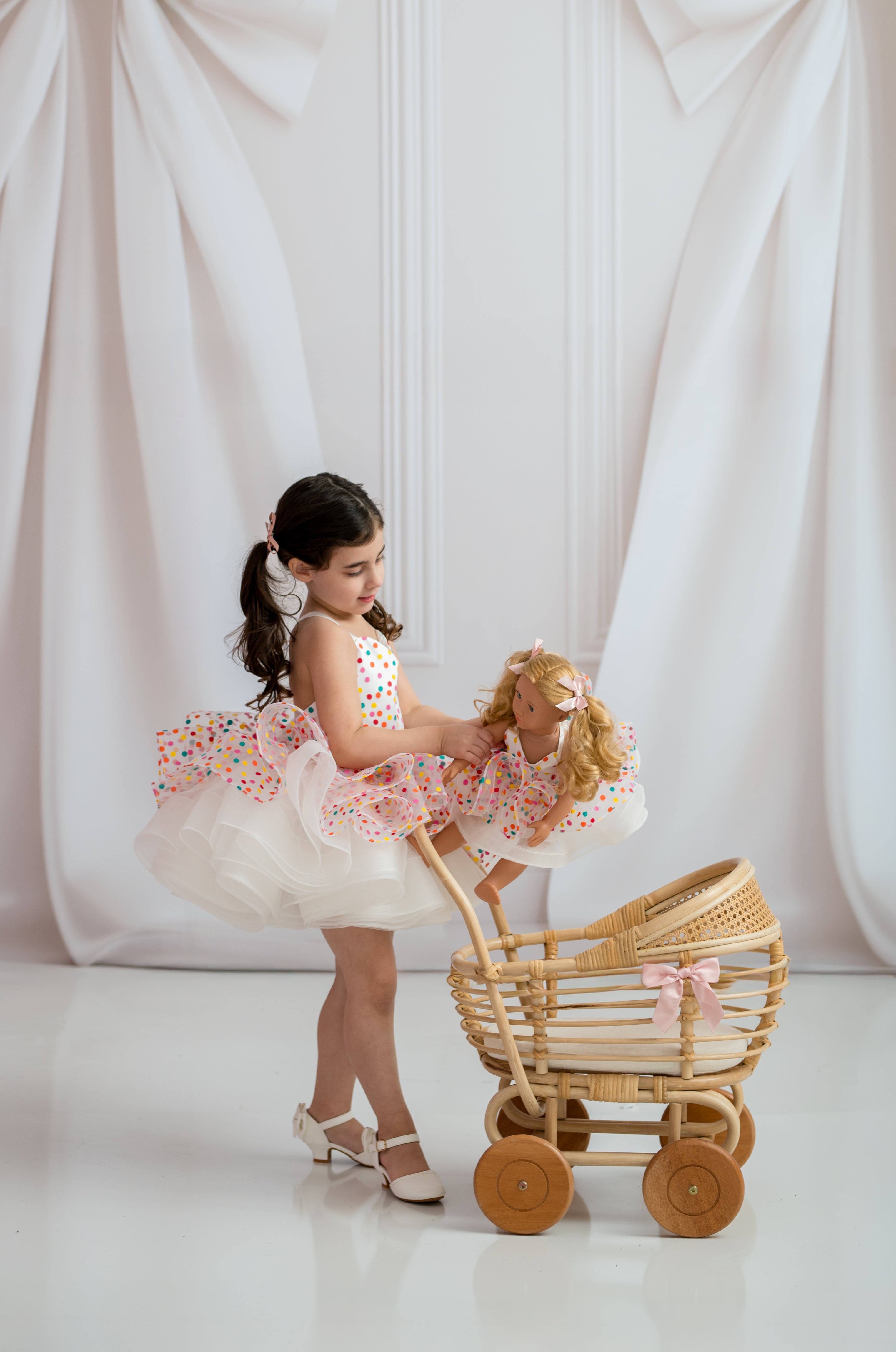 Designer children’s dress displayed on mannequin against fine art white backdrop