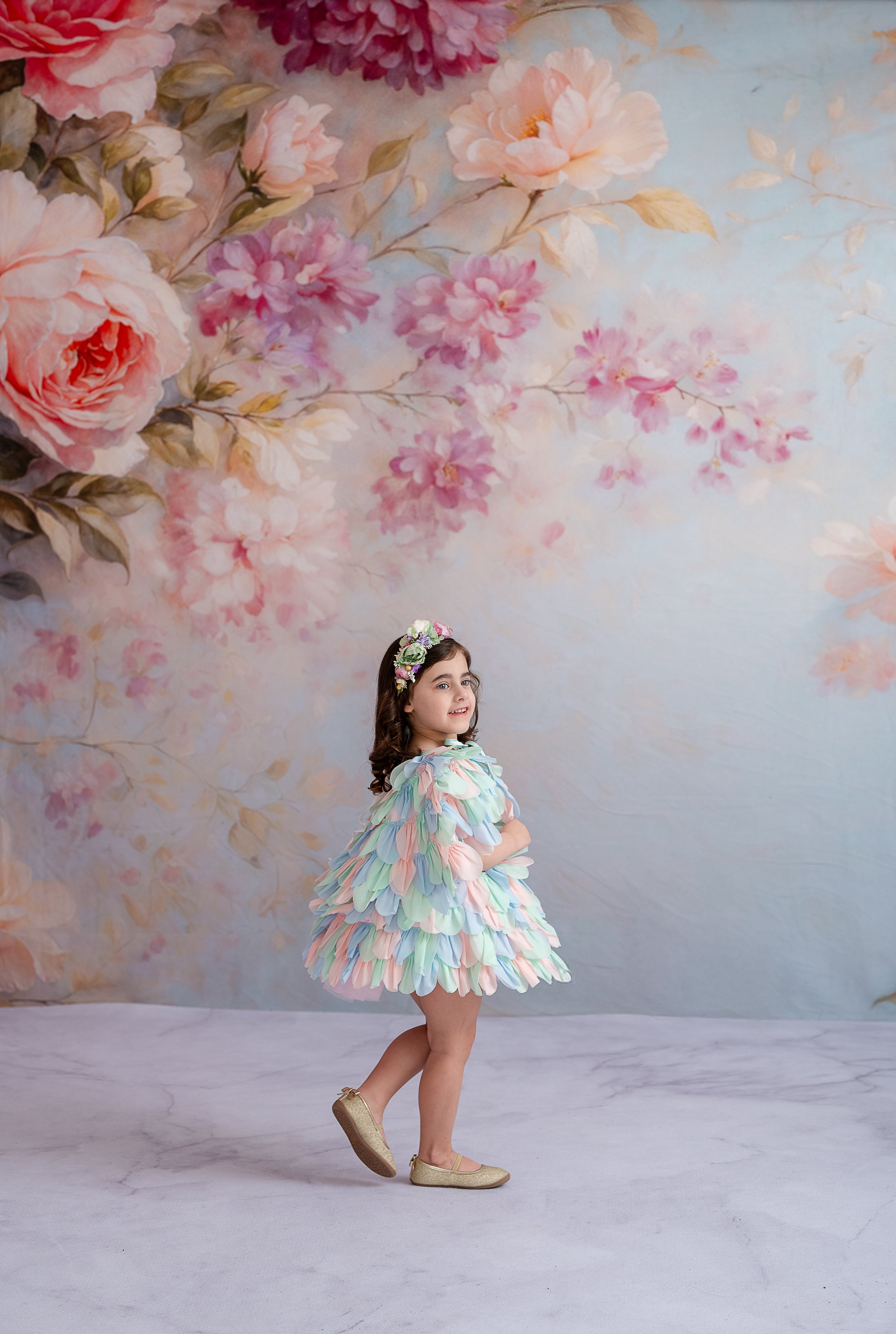 "Delicate and enchanting, a little girl twirls in a multicolored couture gown."
