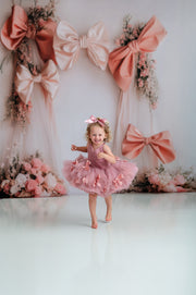 Graceful pink tutu dress with soft polka dot tulle and satin bow accents.

