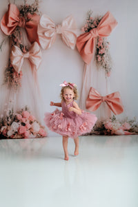 Graceful pink tutu dress with soft polka dot tulle and satin bow accents.

