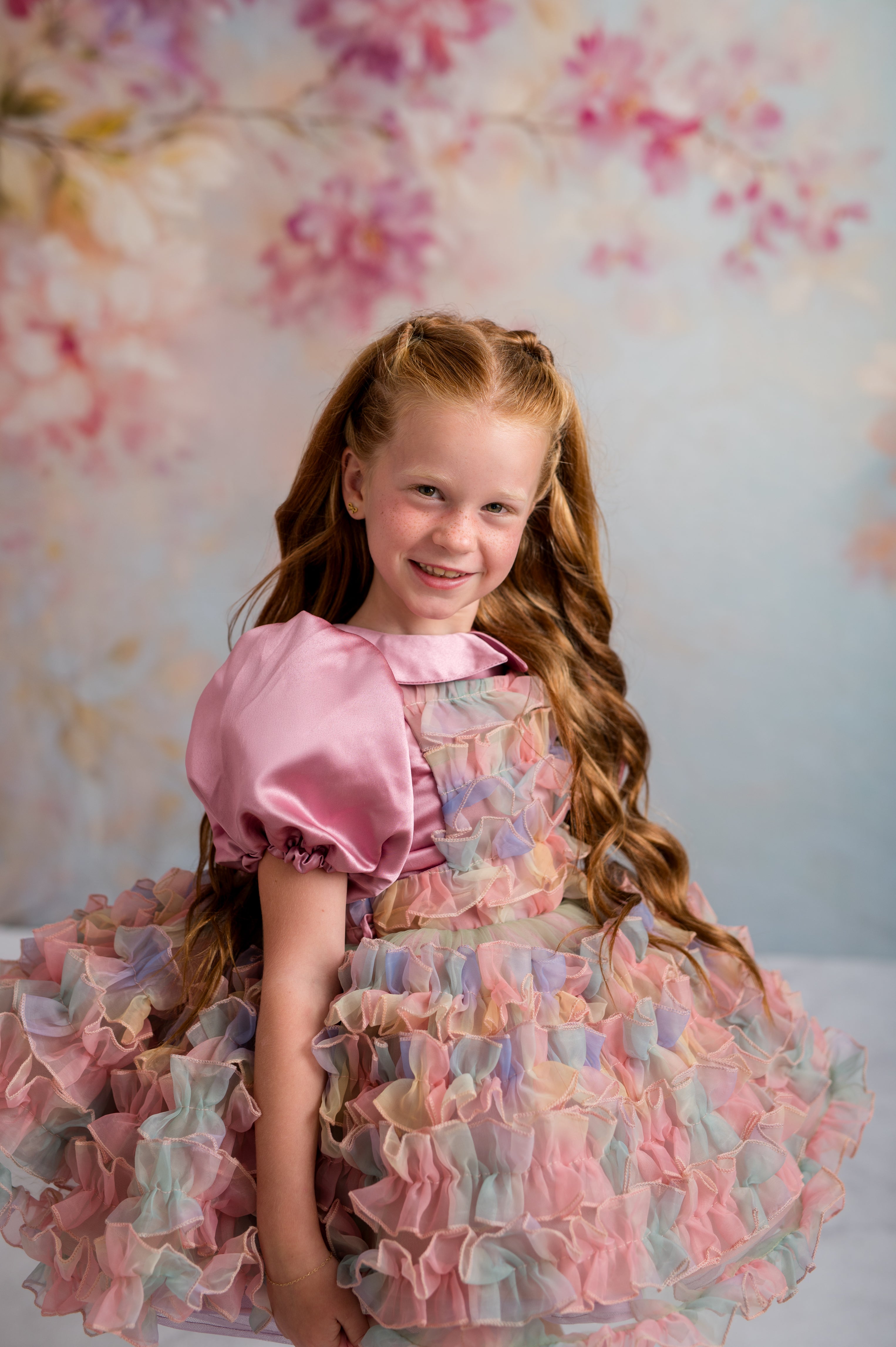 Young girl in a colorful dress with a floral background
